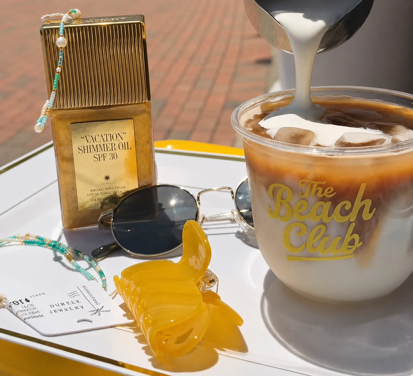 Iced coffee drink at The Beach Club with shimmer oil and sunglasses
