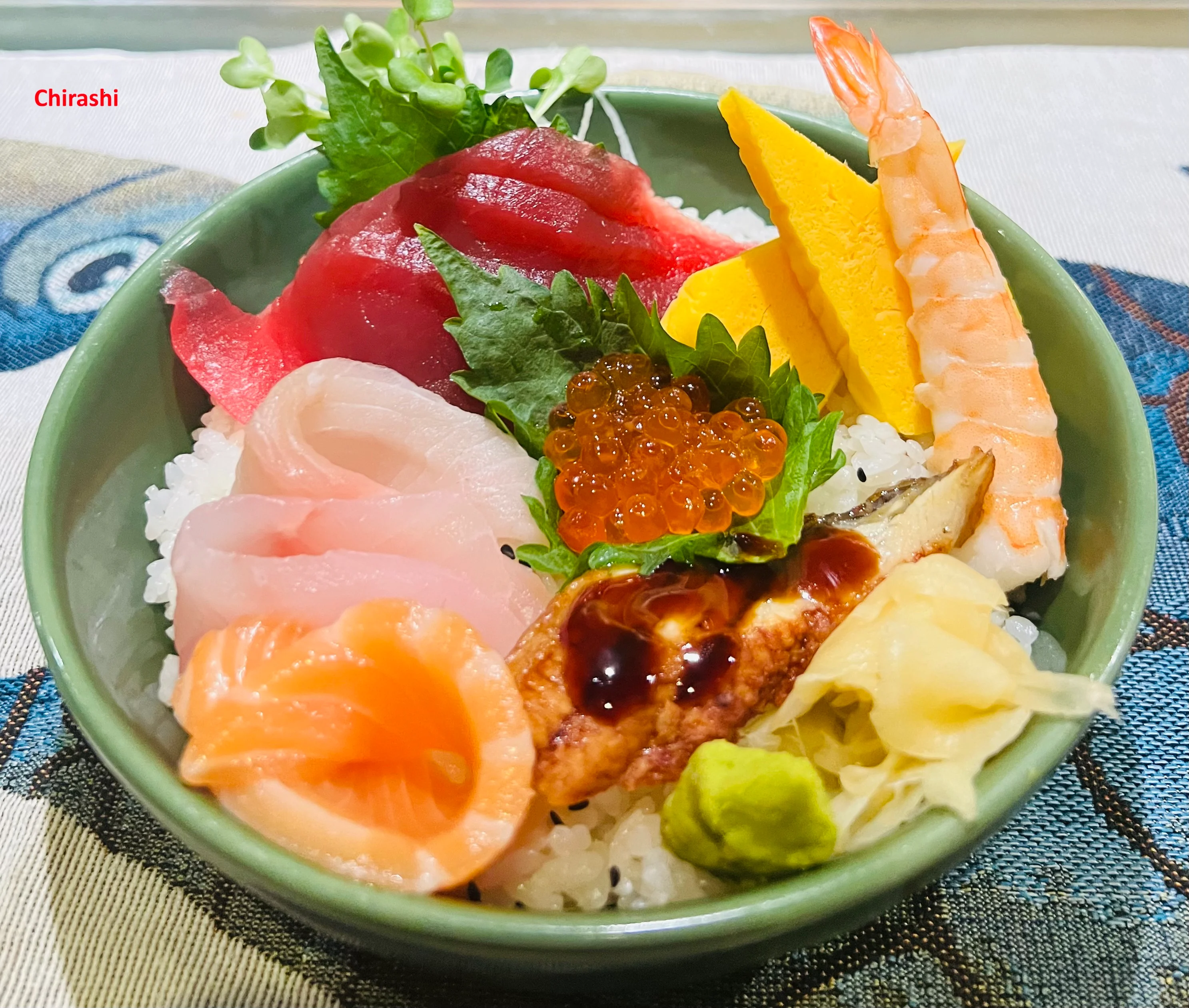 A colorful chirashi bowl featuring assorted sashimi and garnishes.