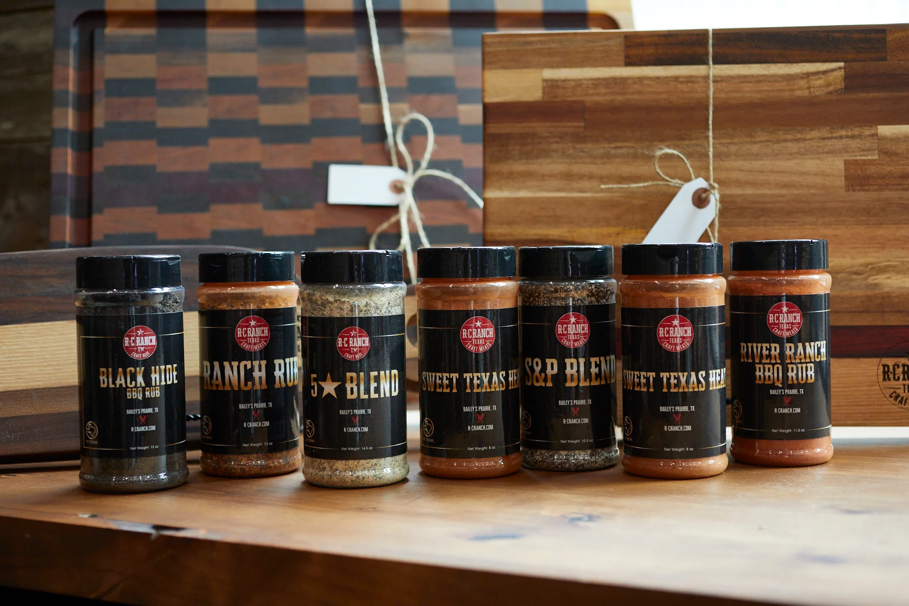 Variety of BBQ rubs from RC Ranch on a wooden table