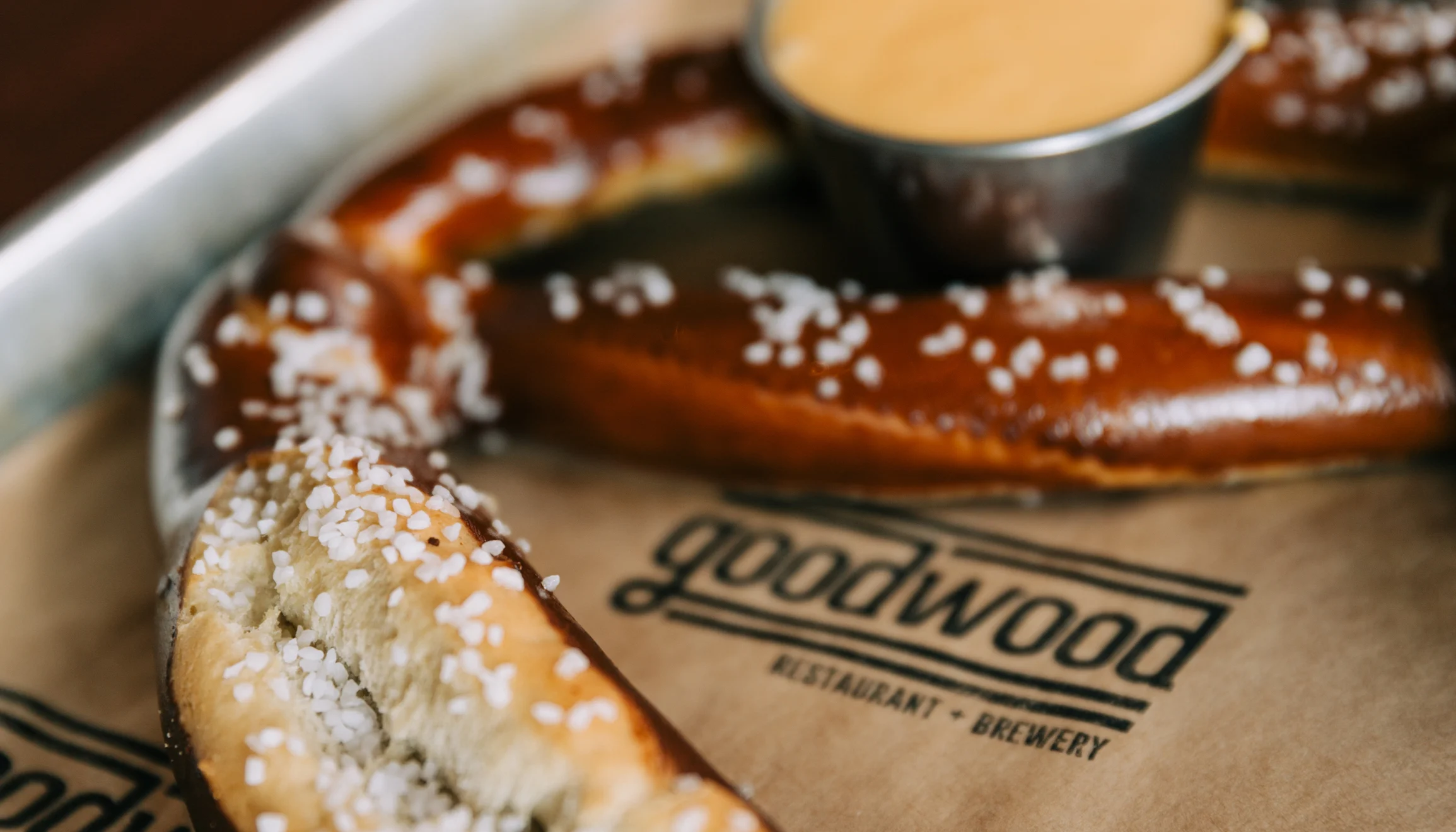 Soft pretzel served with cheese dip in a brewery setting
