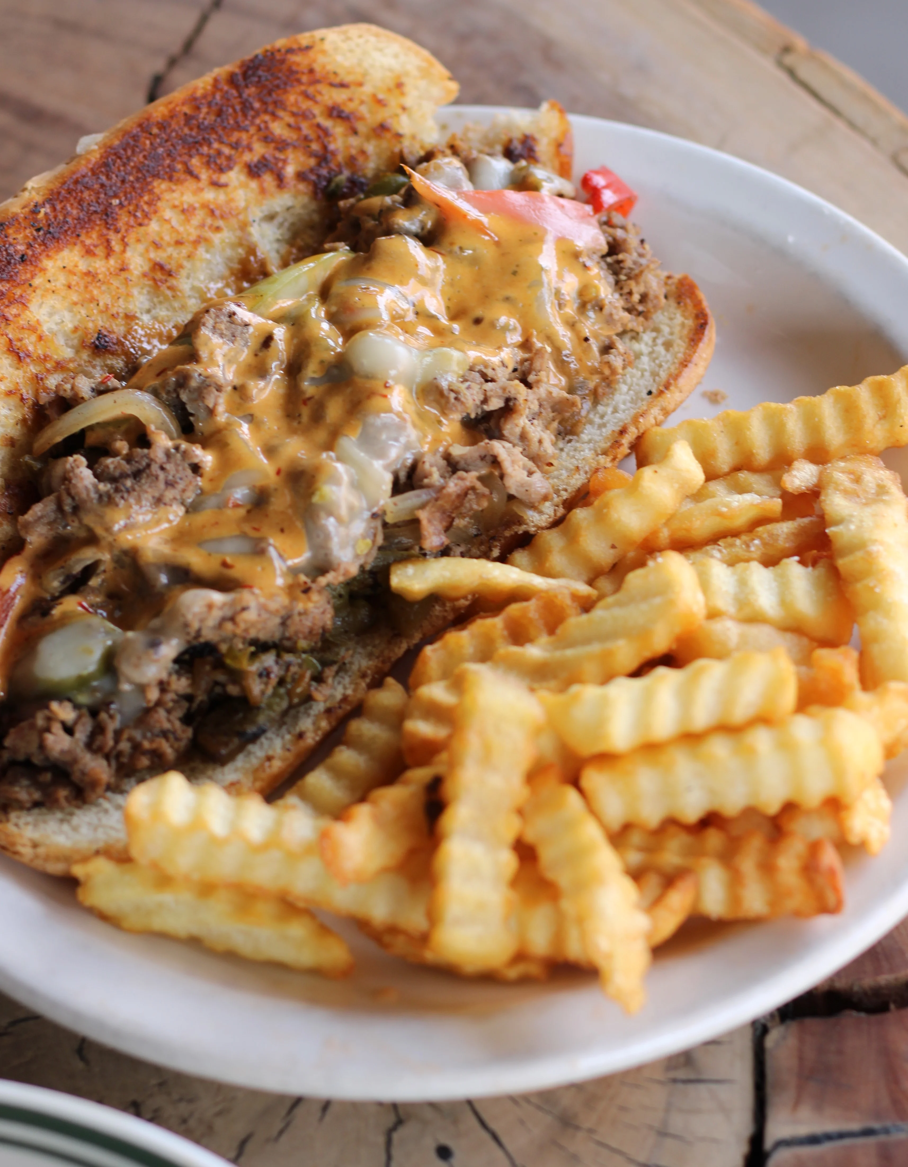 Philly cheesesteak sandwich with crinkle-cut fries