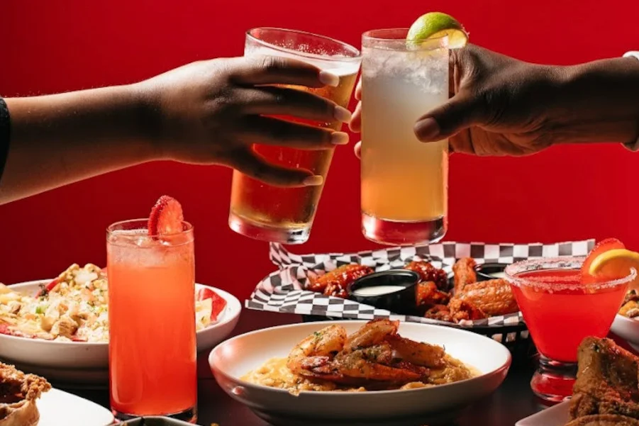 Cheers with cocktails and Southern comfort food spread on a table