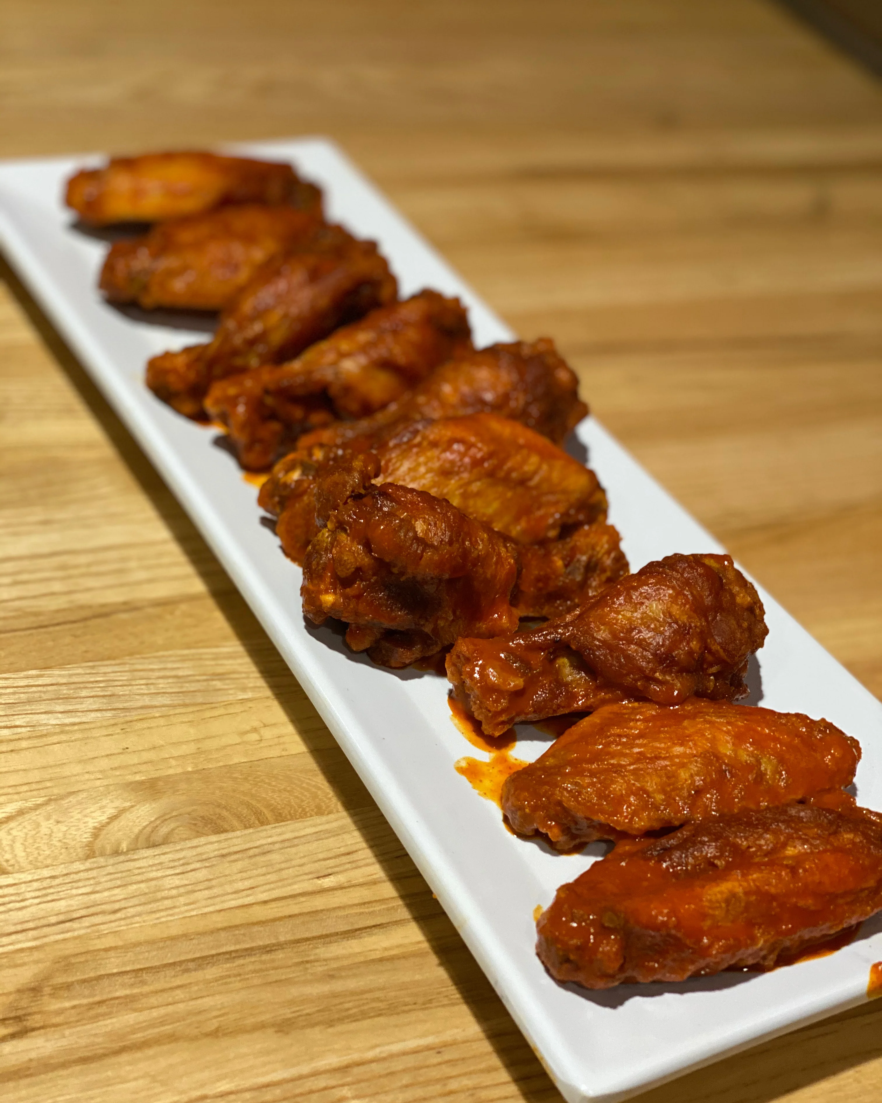 Spicy buffalo chicken wings on a white platter