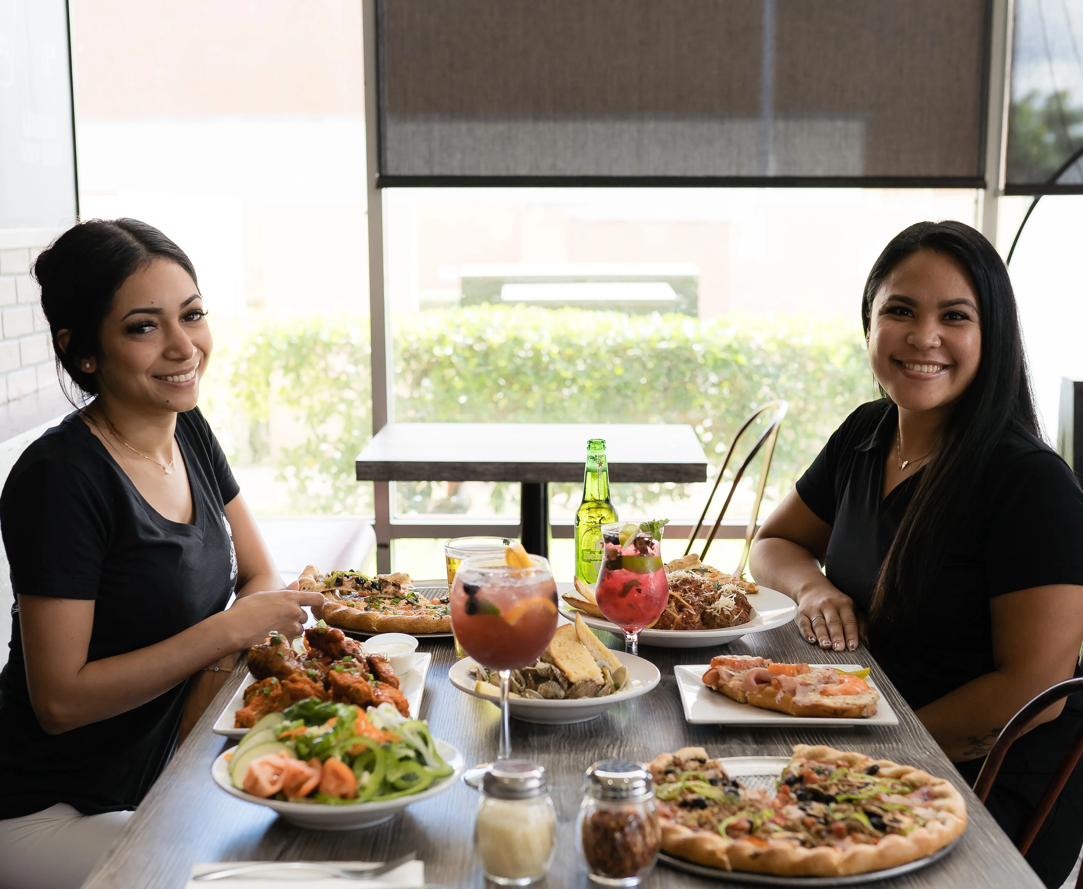 Two friends enjoying a variety of dishes in a cozy restaurant setting
