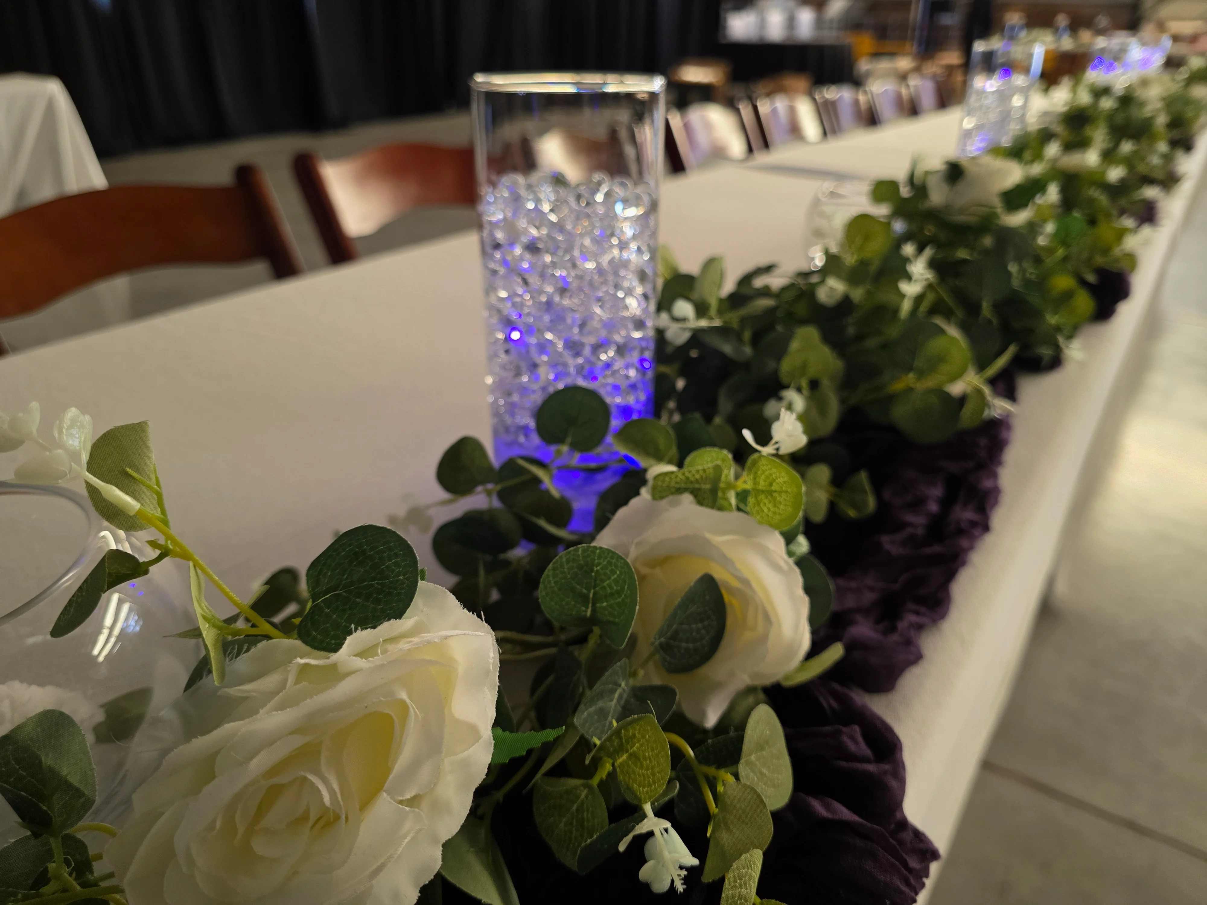 Elegant table setting with floral decor and illuminated centerpieces.