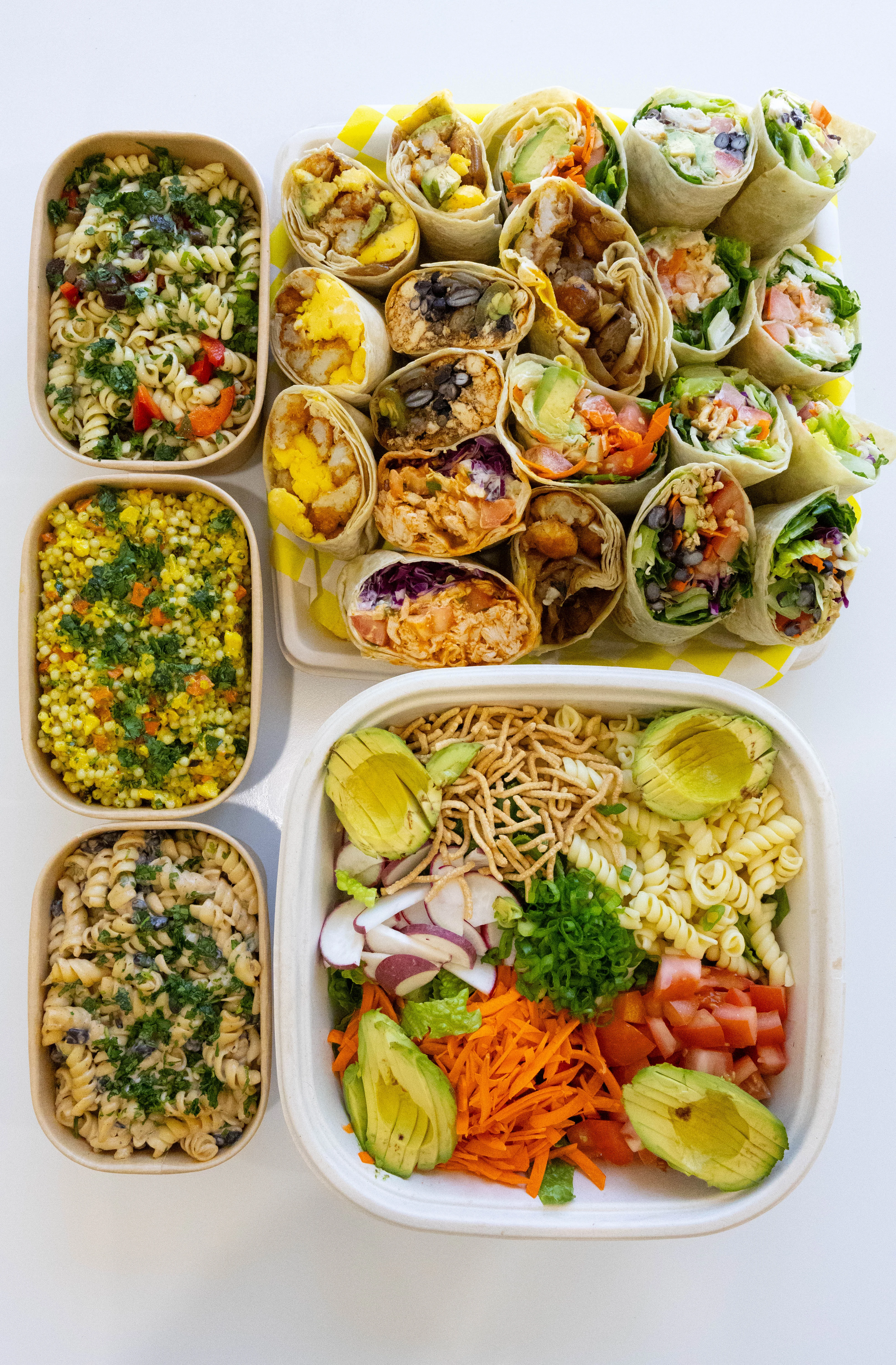 Assorted wraps and pasta salads in a vibrant, healthy meal spread