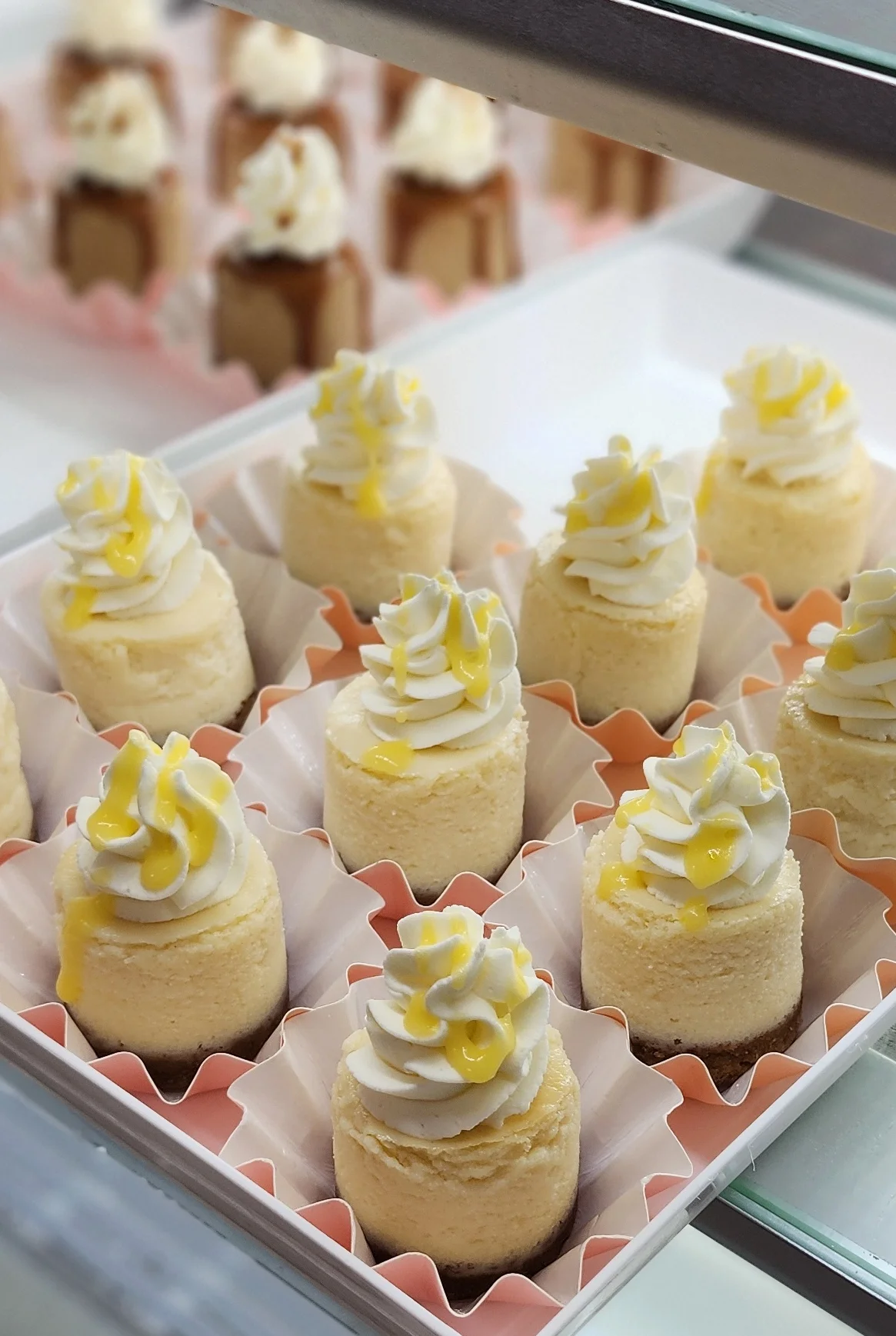 Mini cheesecakes with whipped cream and lemon drizzle