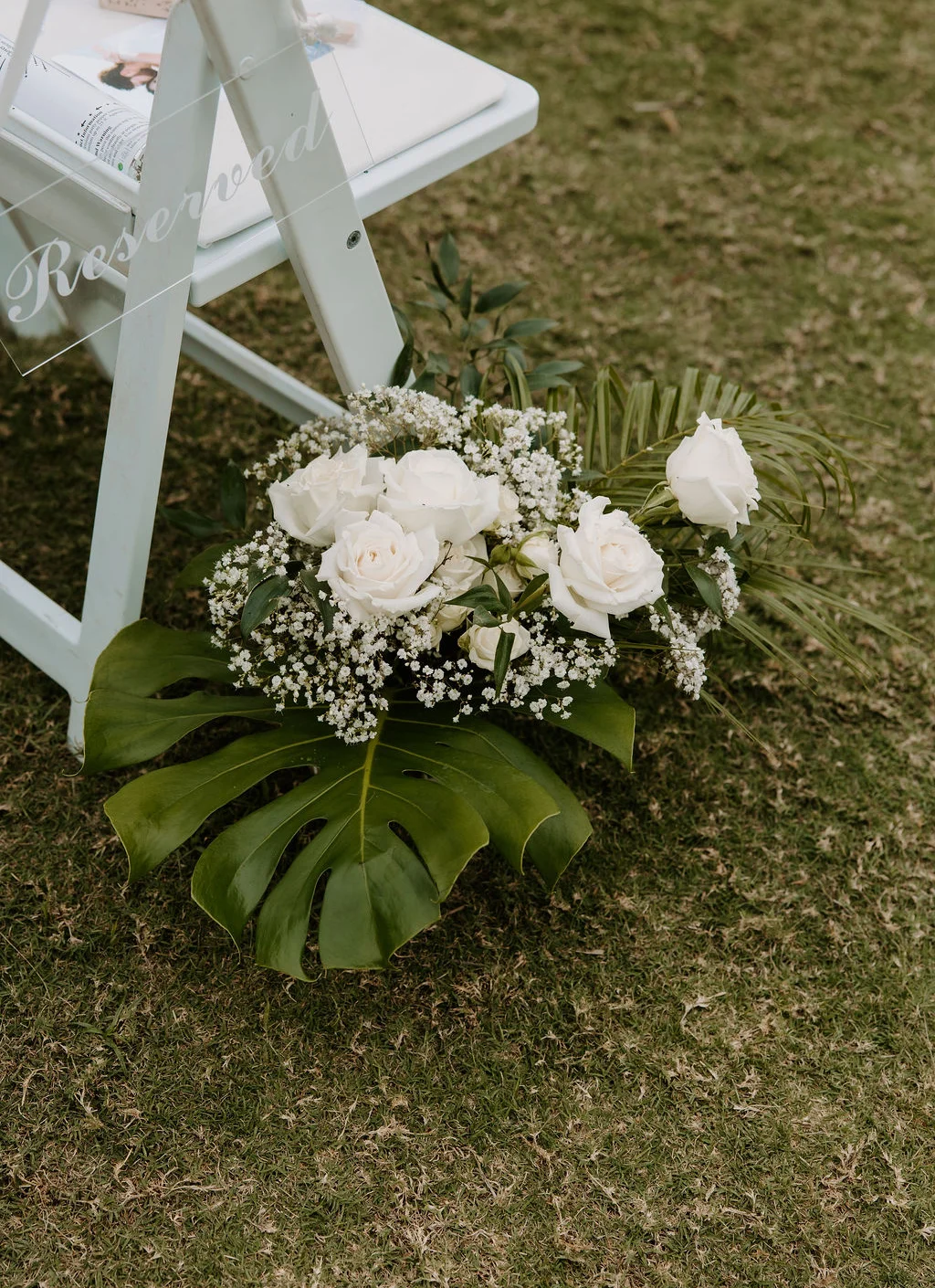 Reserved seating with elegant white roses and greenery