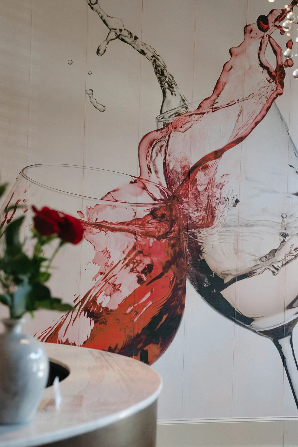 Artistic wall mural of wine glasses with splashing red wine