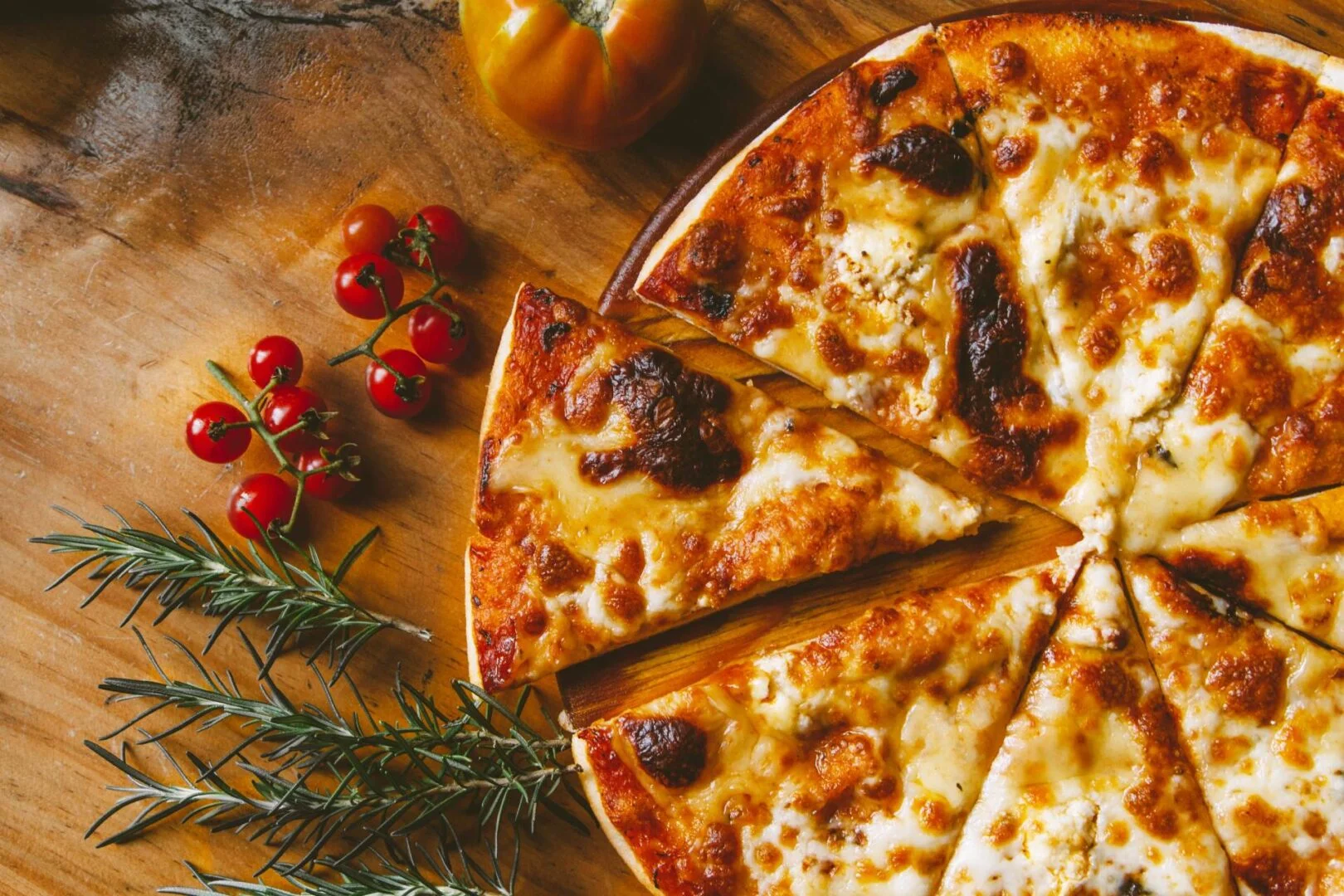 Cheesy Margherita pizza on a wooden table