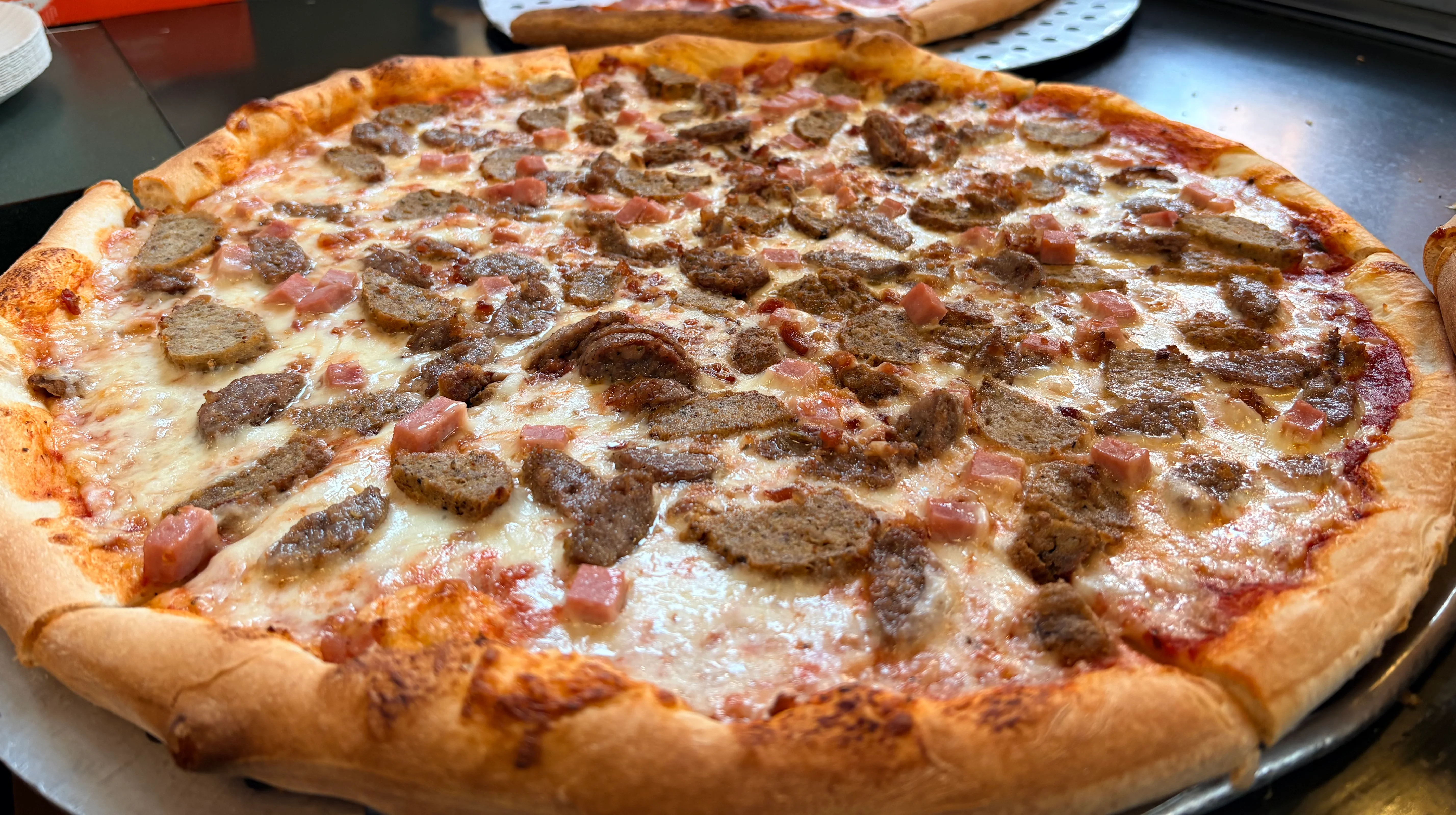 Sicilian-style pizza topped with sausage and ham