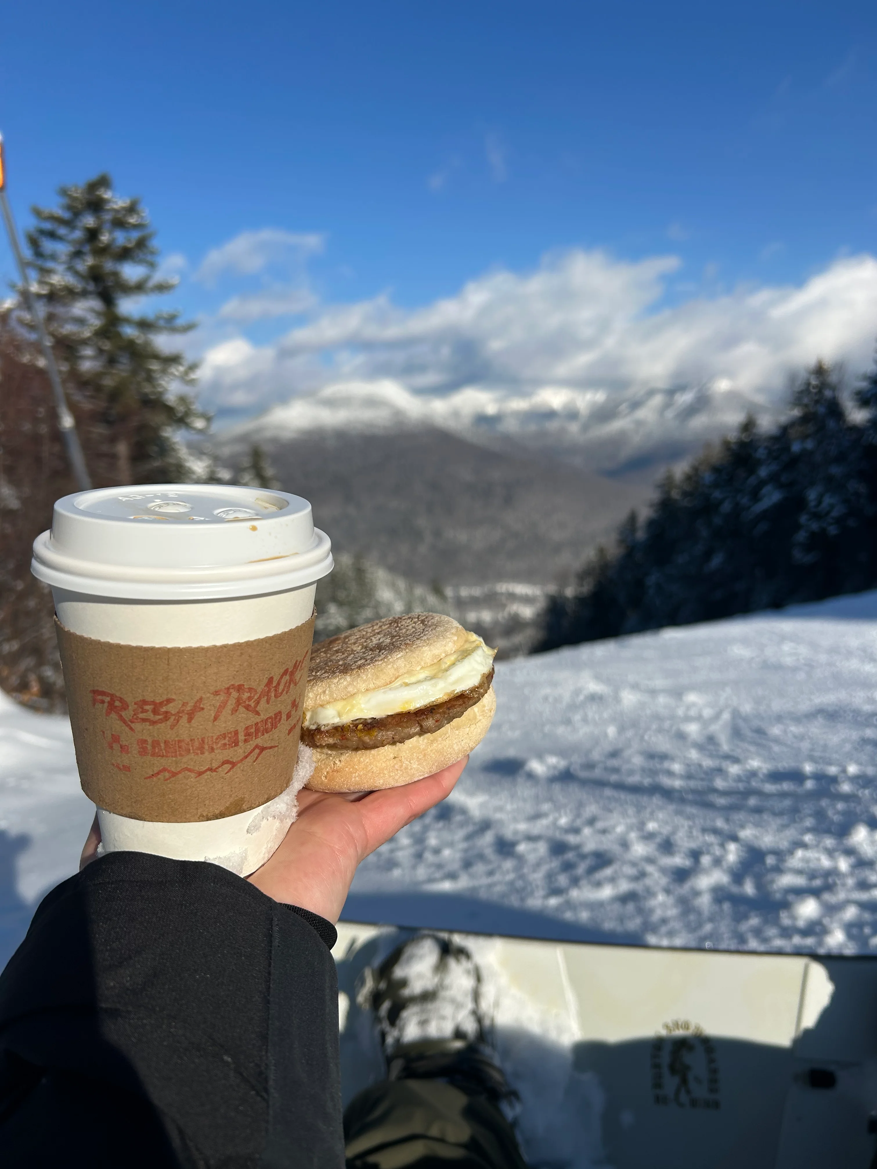 Breakfast sandwich and coffee on a snowy mountain slope
