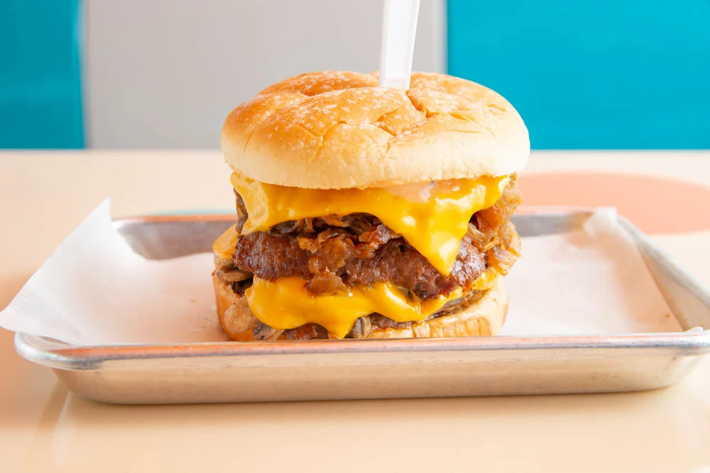 Delicious gourmet burger with fresh toppings on a wooden table