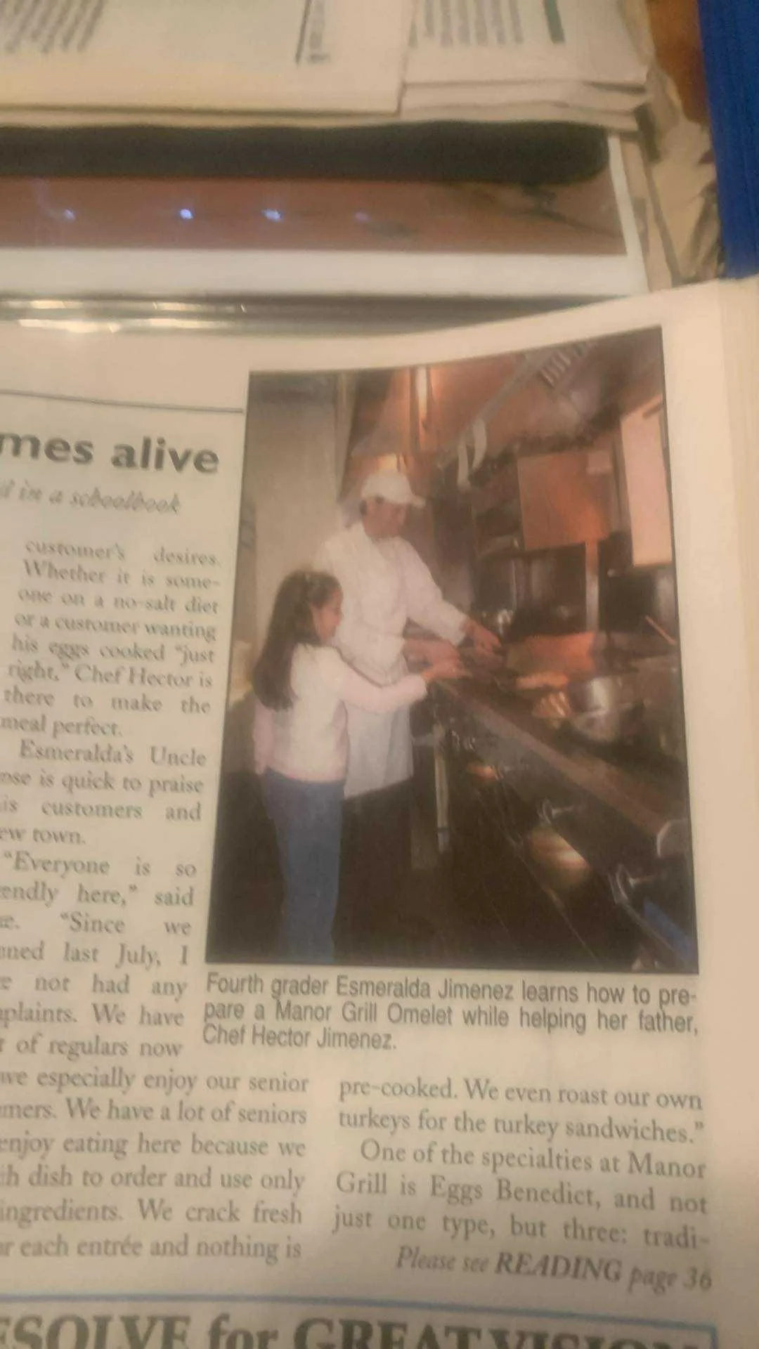 Chef teaching child to make an omelet in a restaurant kitchen