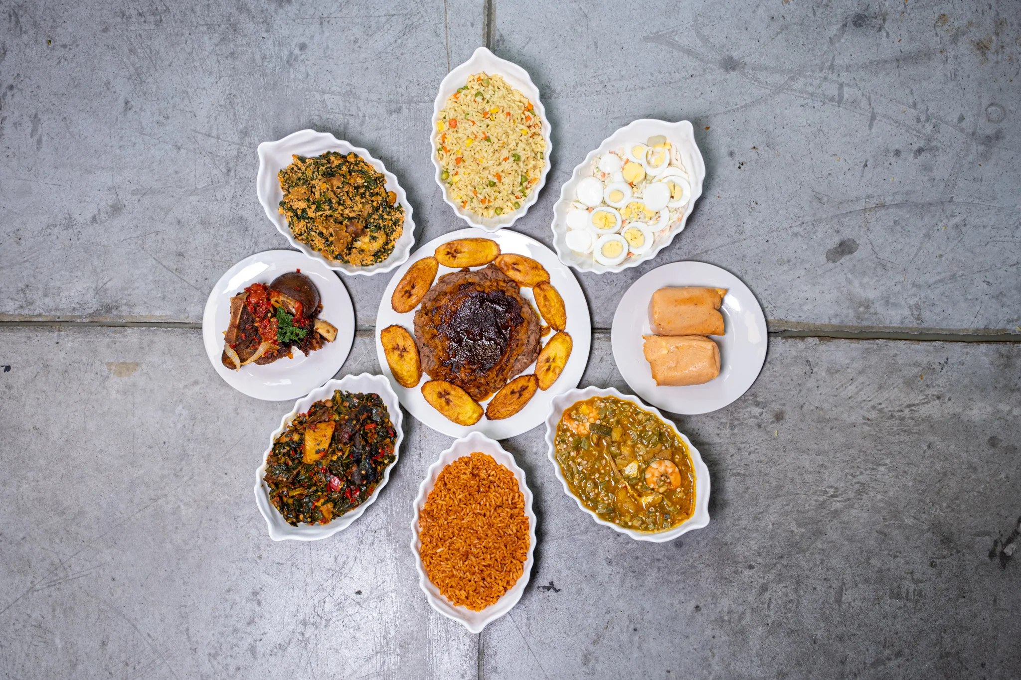 Nigerian jollof rice with assorted dishes in a vibrant spread