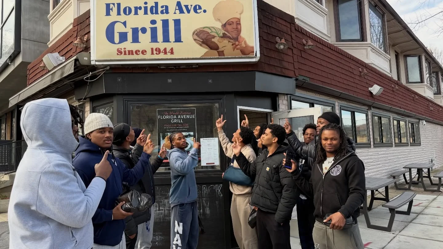 Group outside Florida Avenue Grill restaurant beneath vintage exterior signage