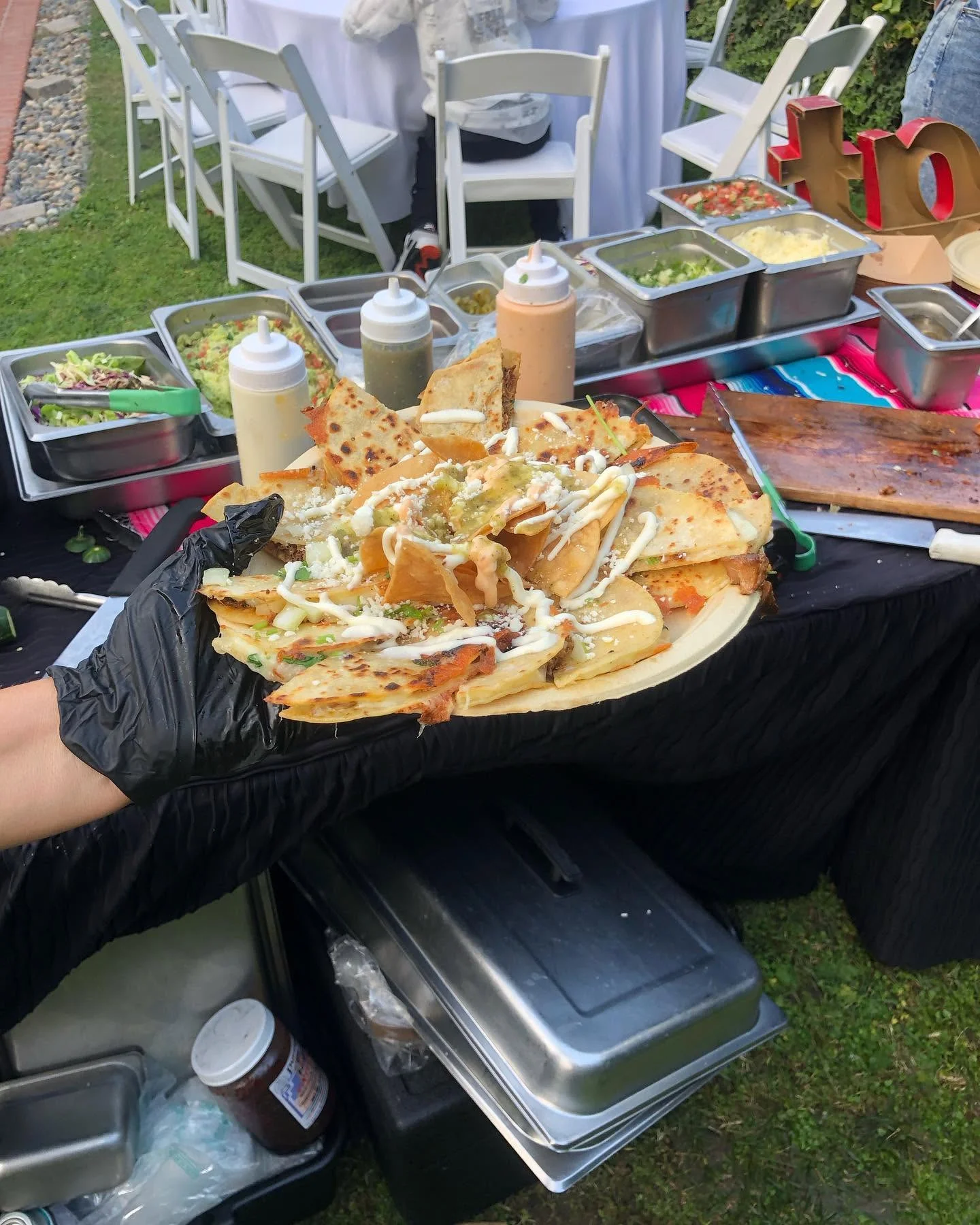 Plate of loaded nachos with toppings at an outdoor event
