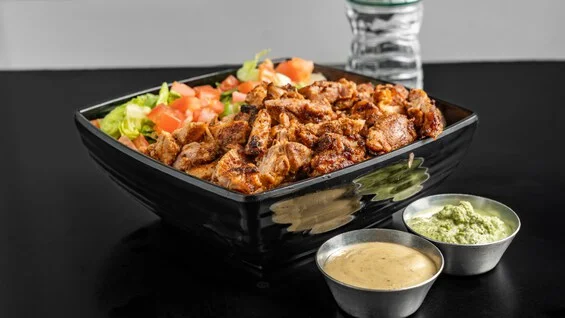 Middle Eastern chicken shawarma platter with salad and dipping sauces