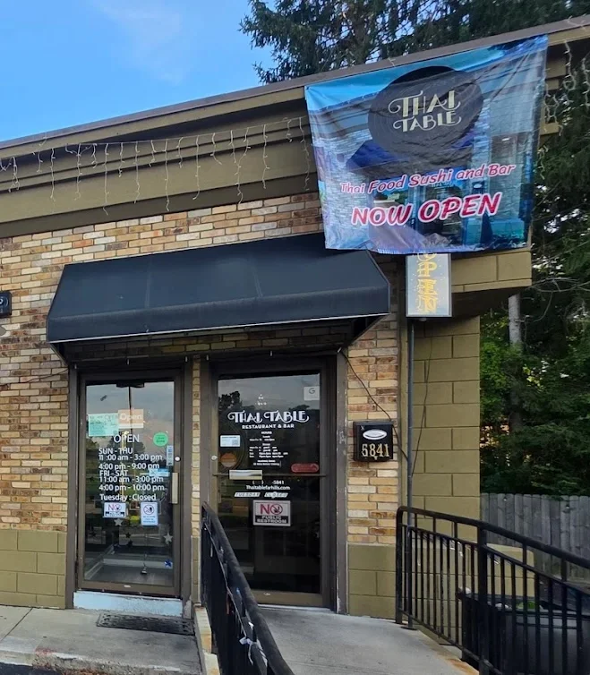 Exterior of Thai Table restaurant with open sign and banners