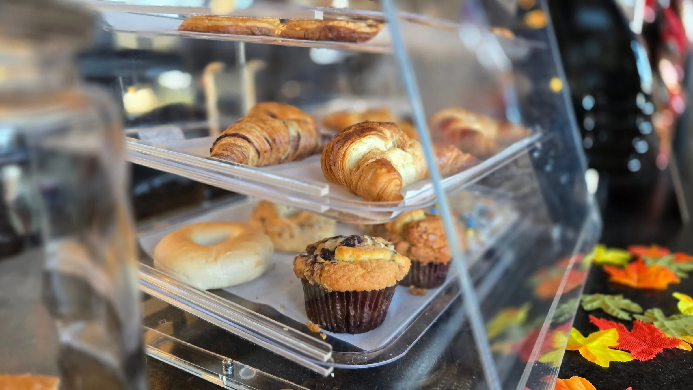 Assorted pastries including croissants and muffins in a bakery display