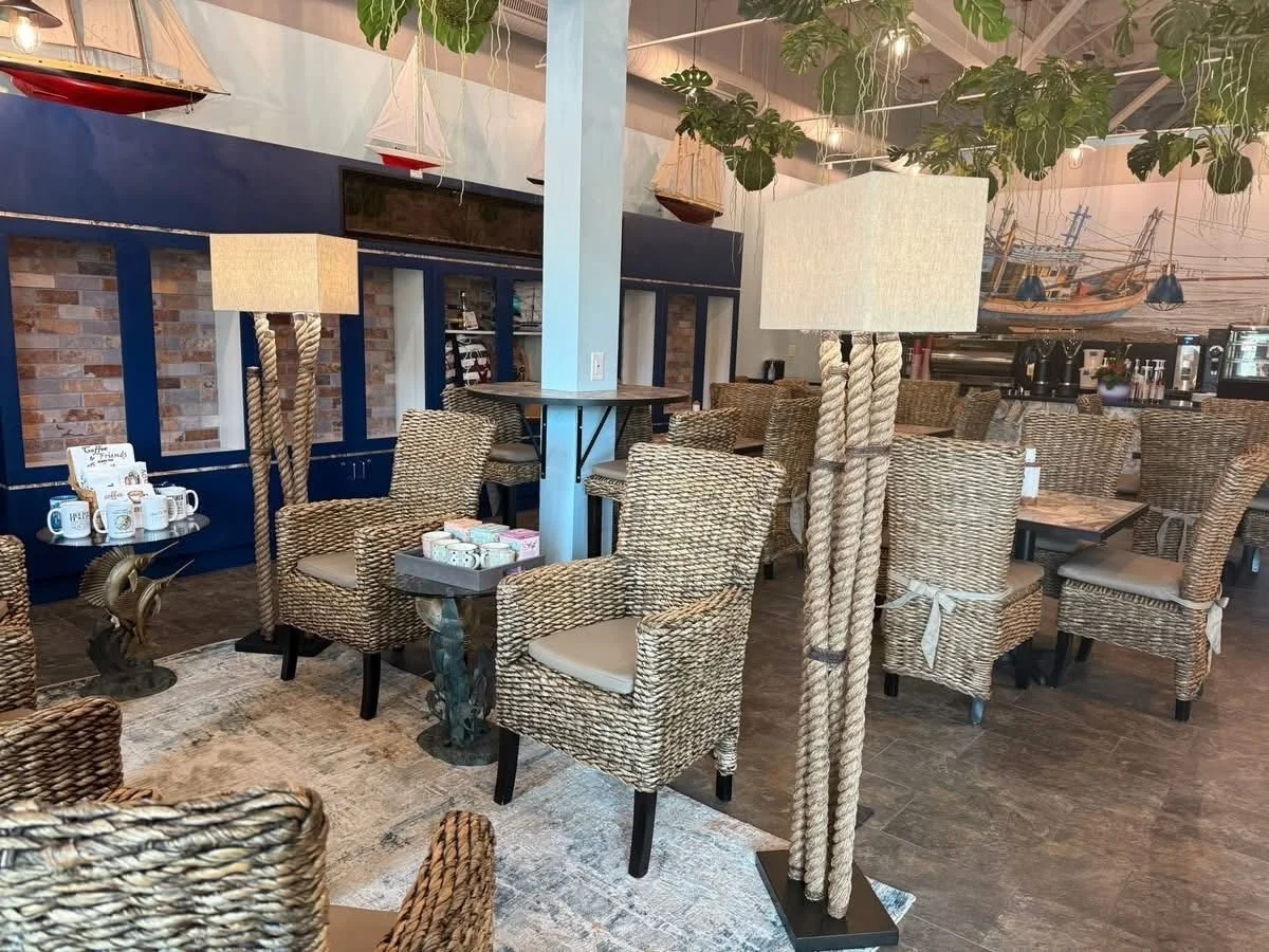 A cozy dining area featuring wicker chairs and a unique lamp. The walls are decorated with nautical elements, creating a relaxed ambiance.