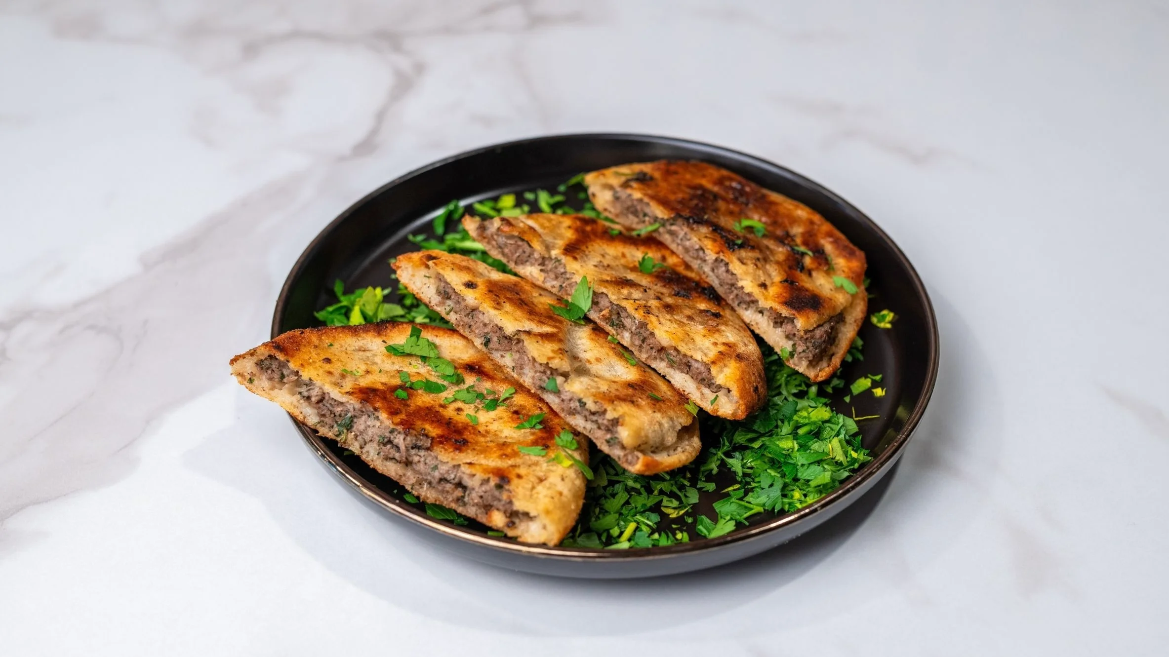 A sumptuous dish of whole quails served on a bed of rice, garnished with cherry tomatoes and herbs. The presentation emphasizes the richness of the meal, ideal for special occasions.