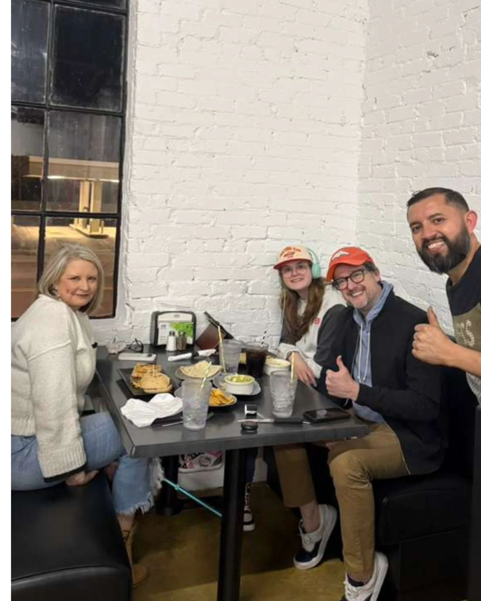 Group enjoying a meal in a cozy restaurant with exposed brick walls