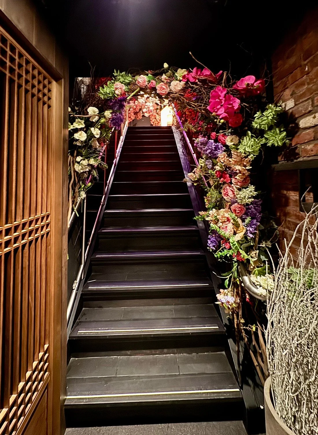 Elegant staircase adorned with vibrant floral arrangements in a restaurant setting