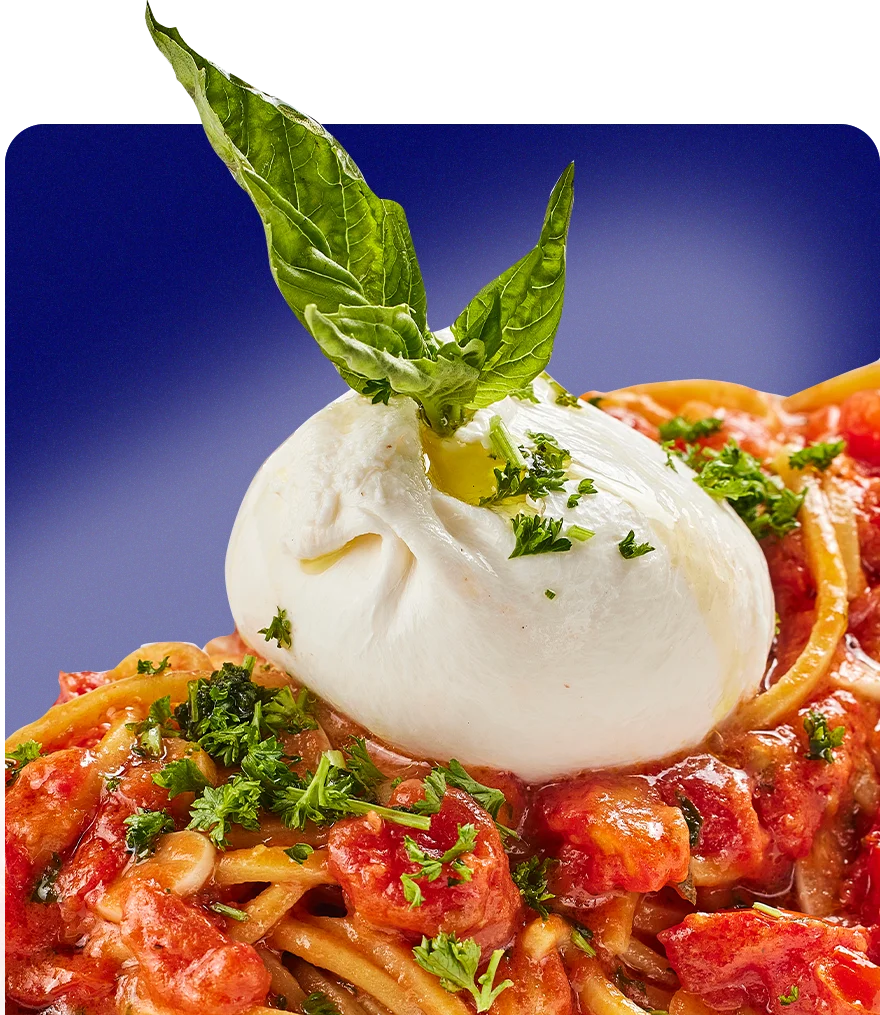 Spaghetti alla Caprese topped with burrata and fresh basil
