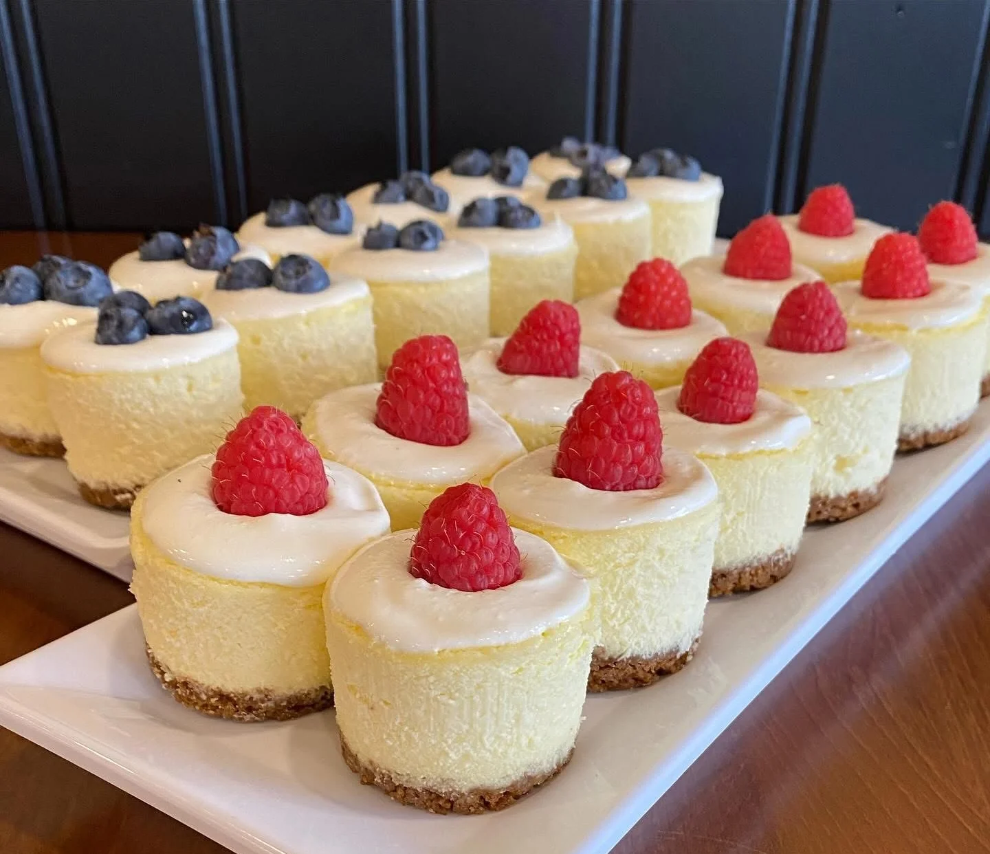 Mini cheesecakes topped with raspberries and blueberries
