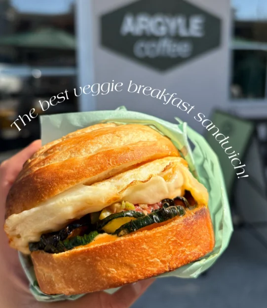 Vegetarian breakfast sandwich with grilled vegetables and melted cheese on a toasted bun
