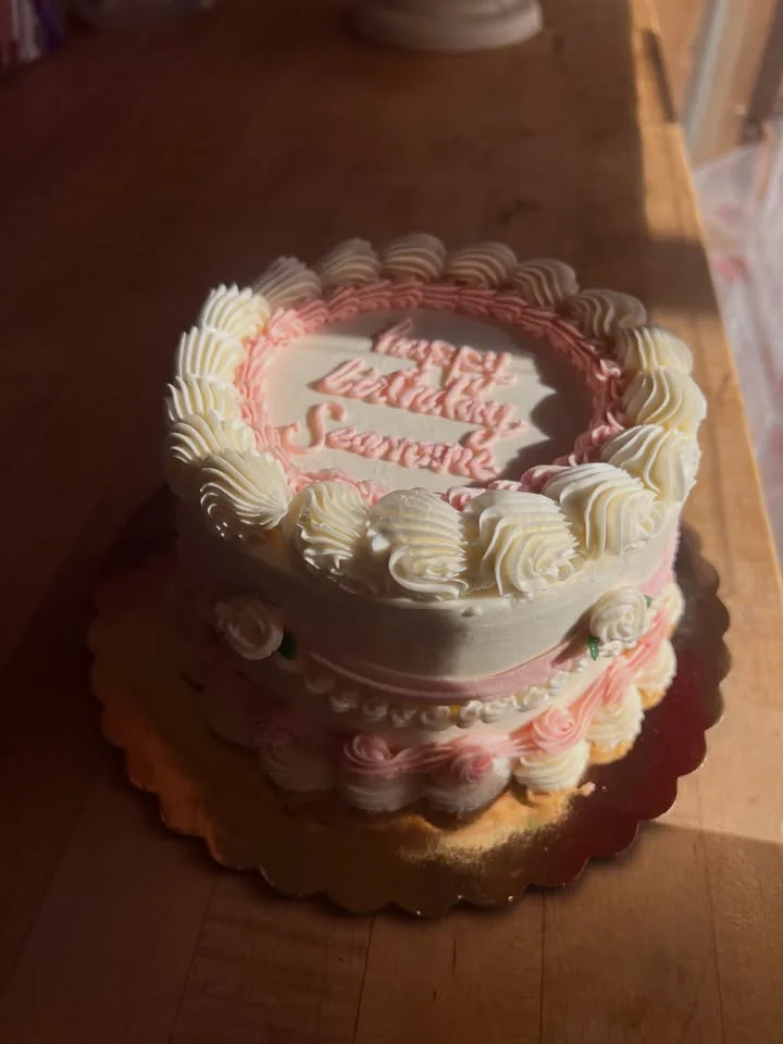 Decorative birthday cake with pink and white frosting