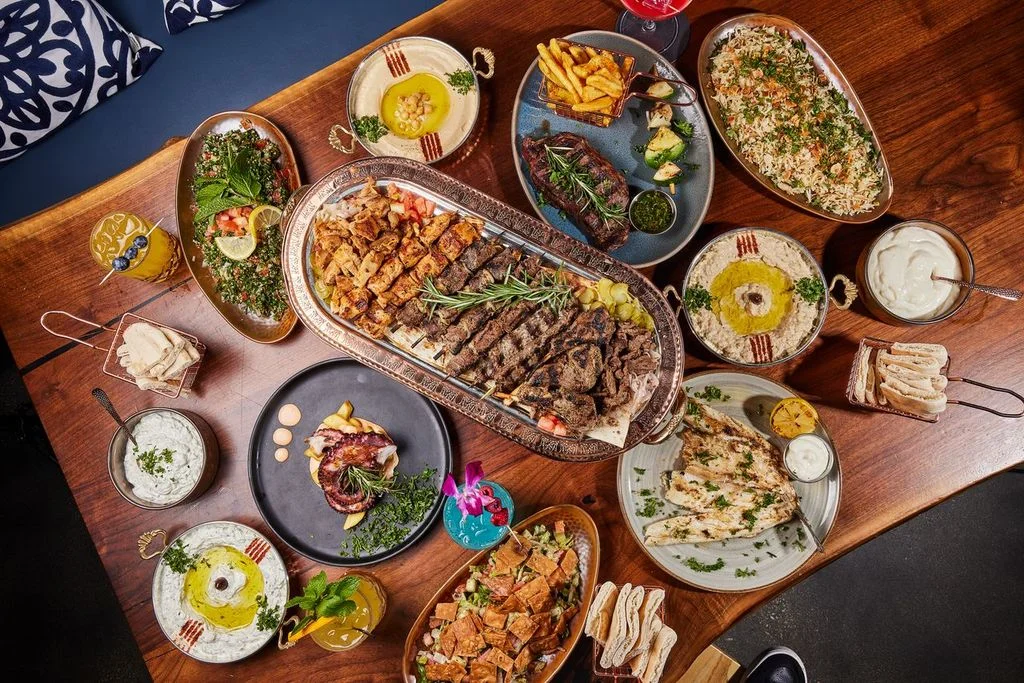 Mediterranean feast with grilled meats, hummus, and rice at Sufrat Grill.