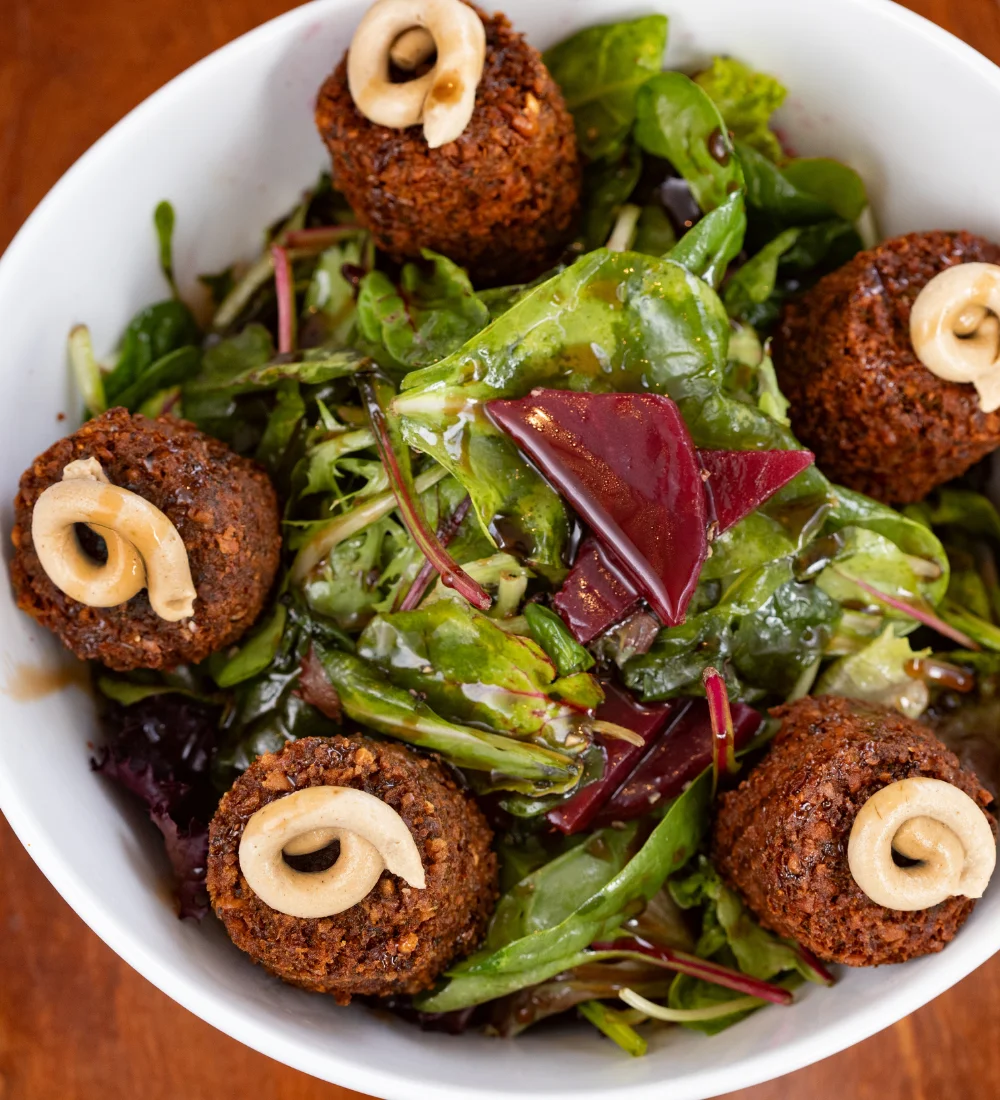 Mediterranean falafel salad with greens and tahini drizzle