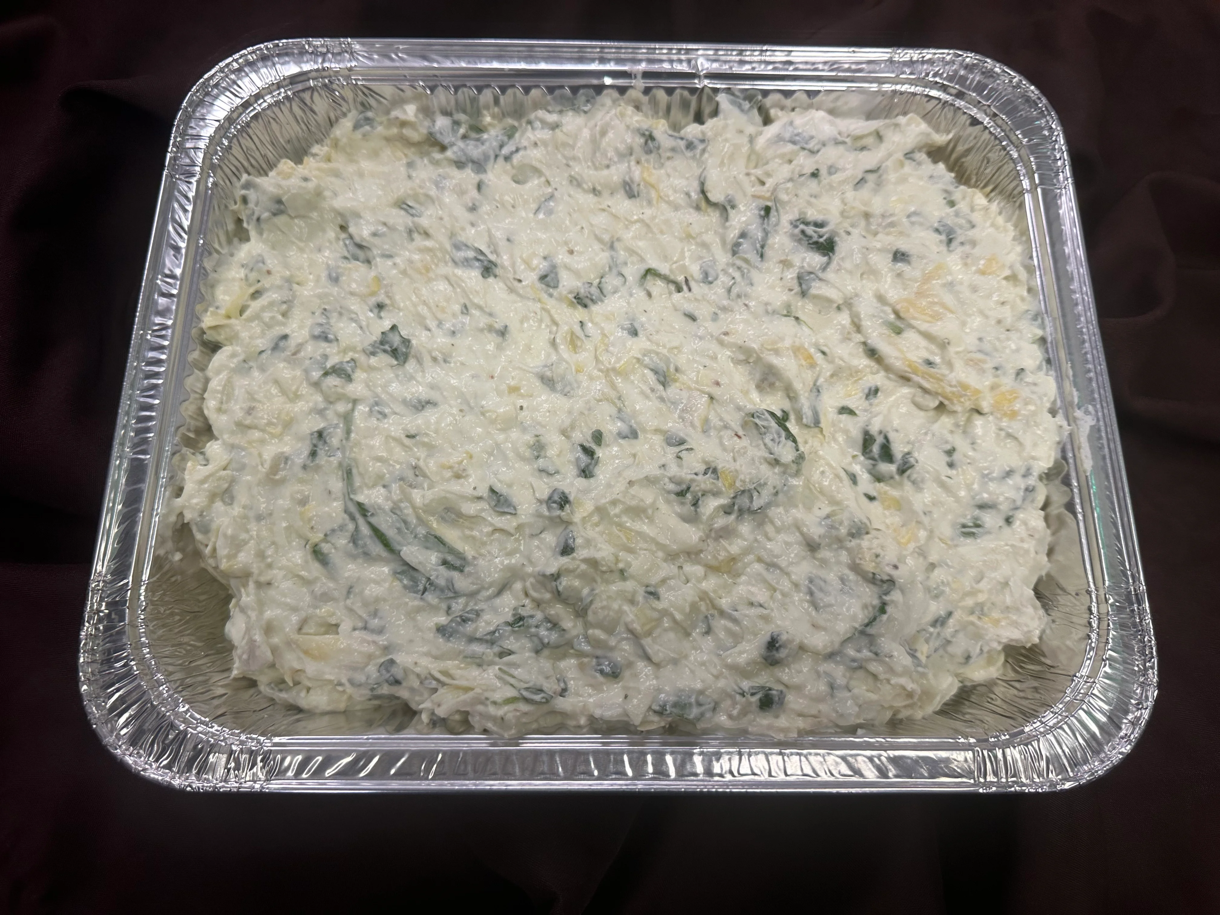 Creamy spinach artichoke dip in a serving tray