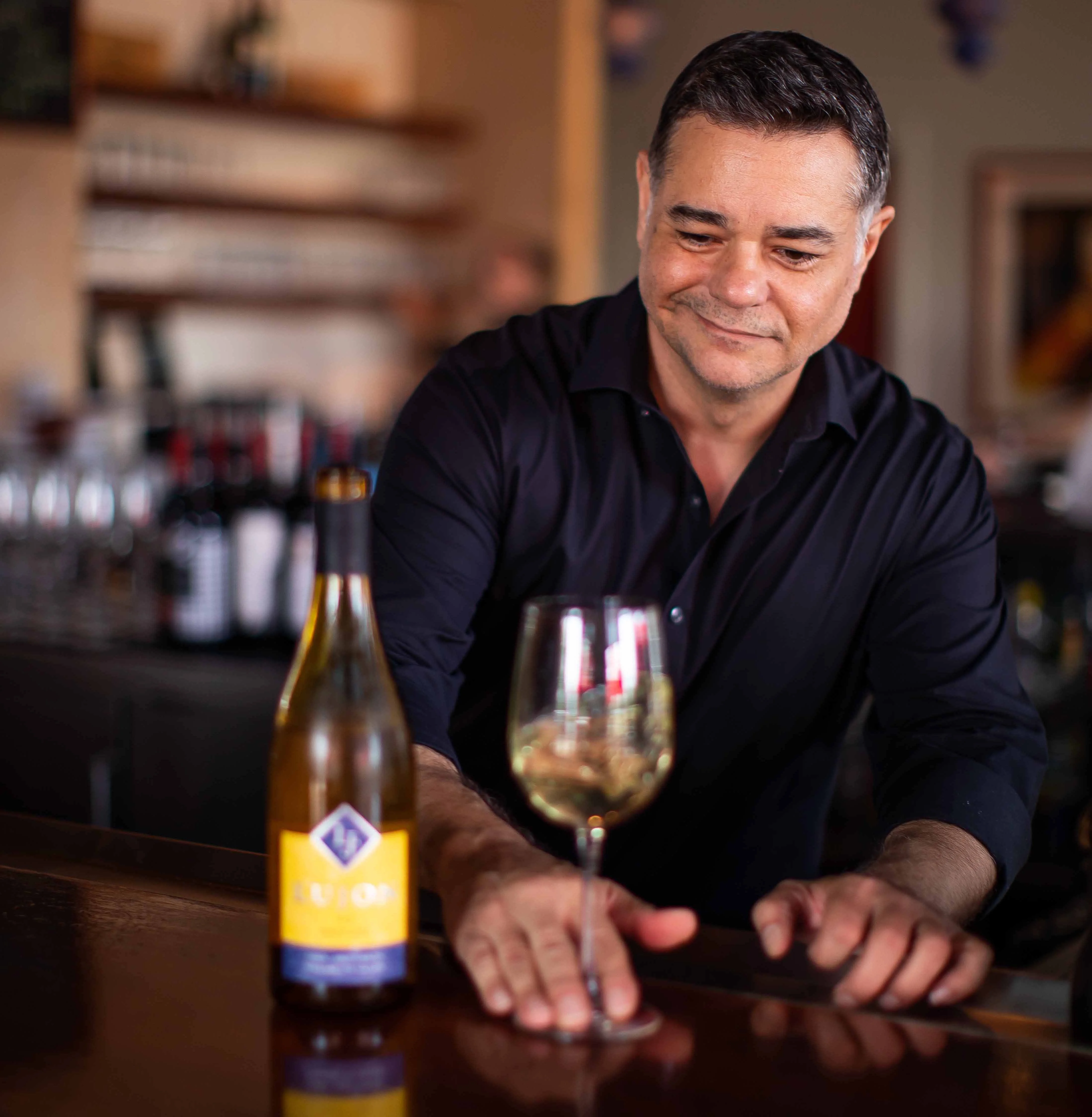 Bartender pouring wine at a stylish bar