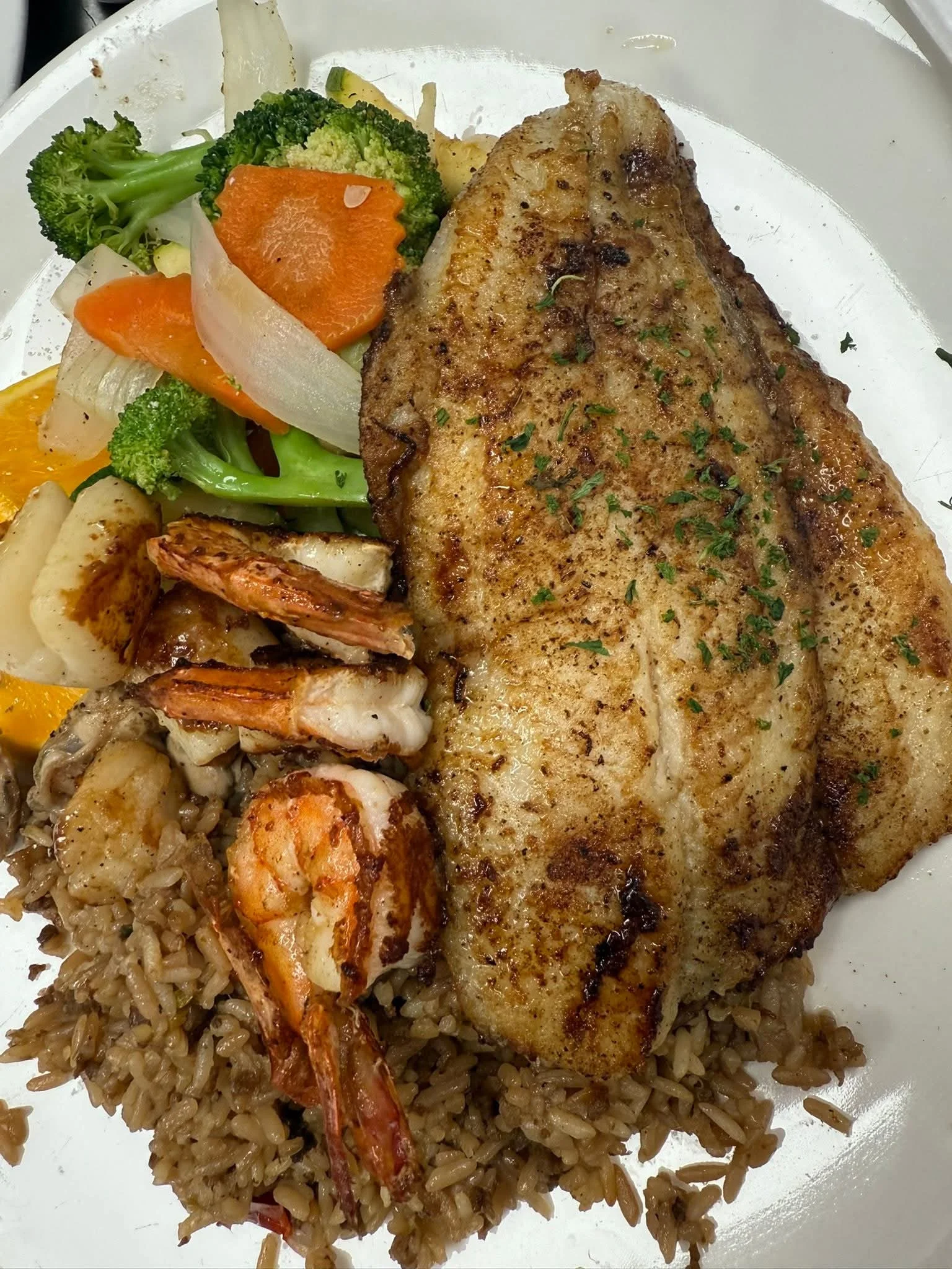 A plate of grilled seafood on a bed of rice