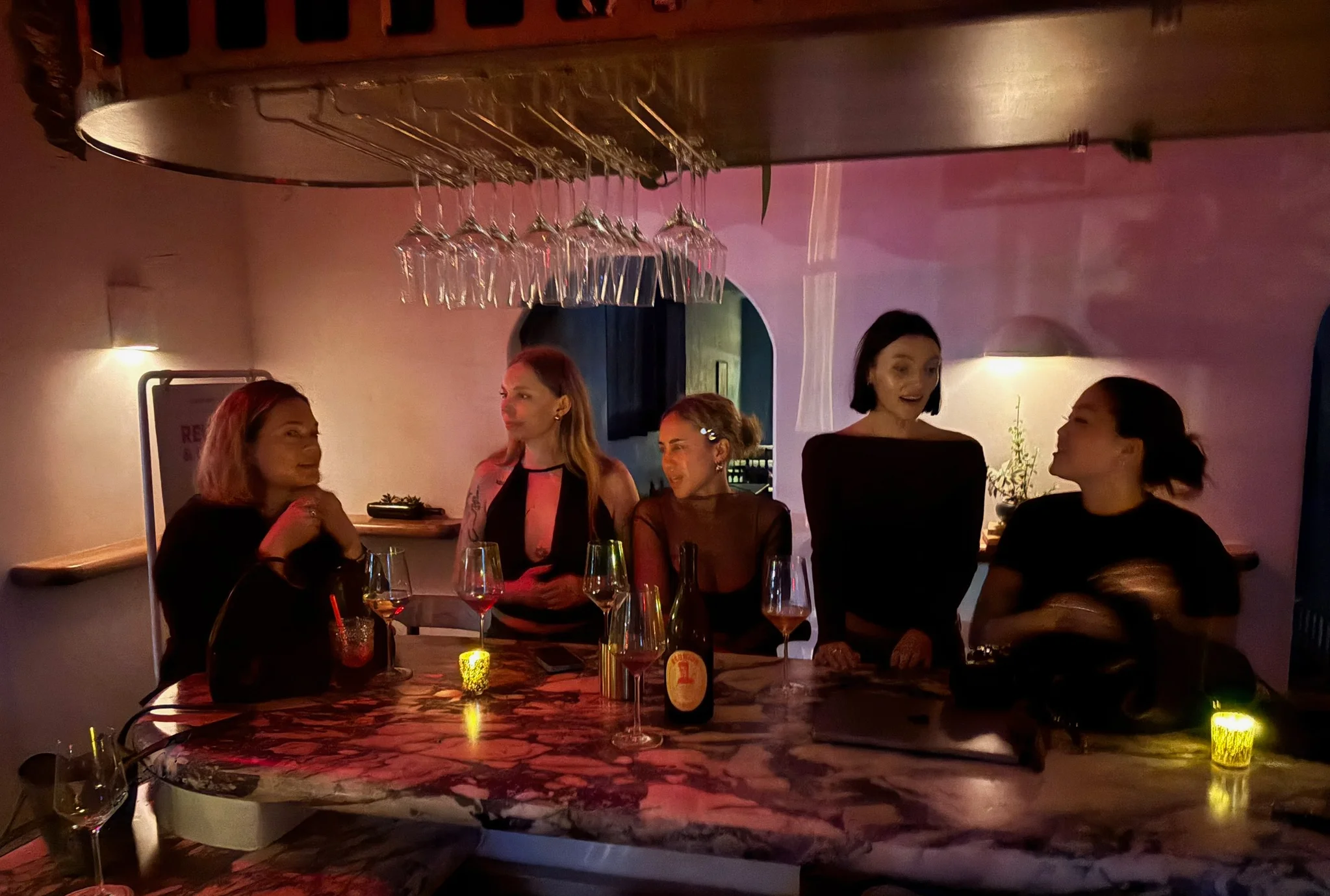 Girls at a bar drinking wine 