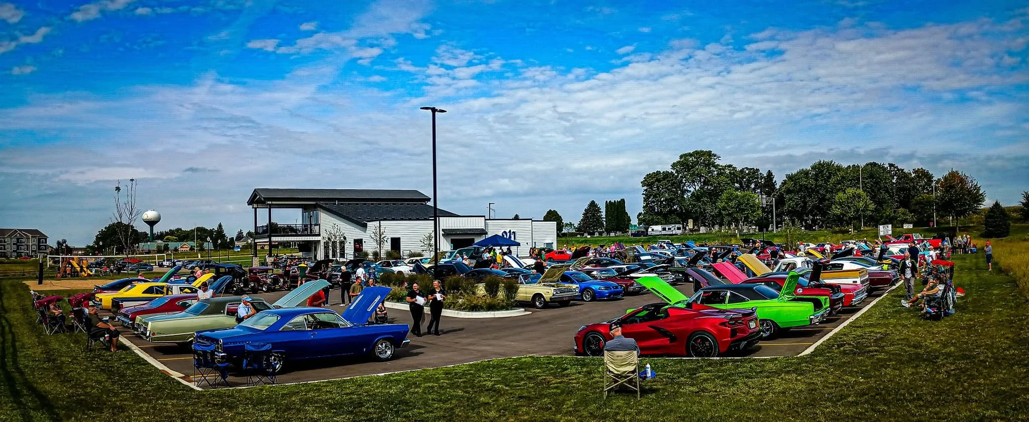 Car show featuring classic and modern cars in a vibrant outdoor setting