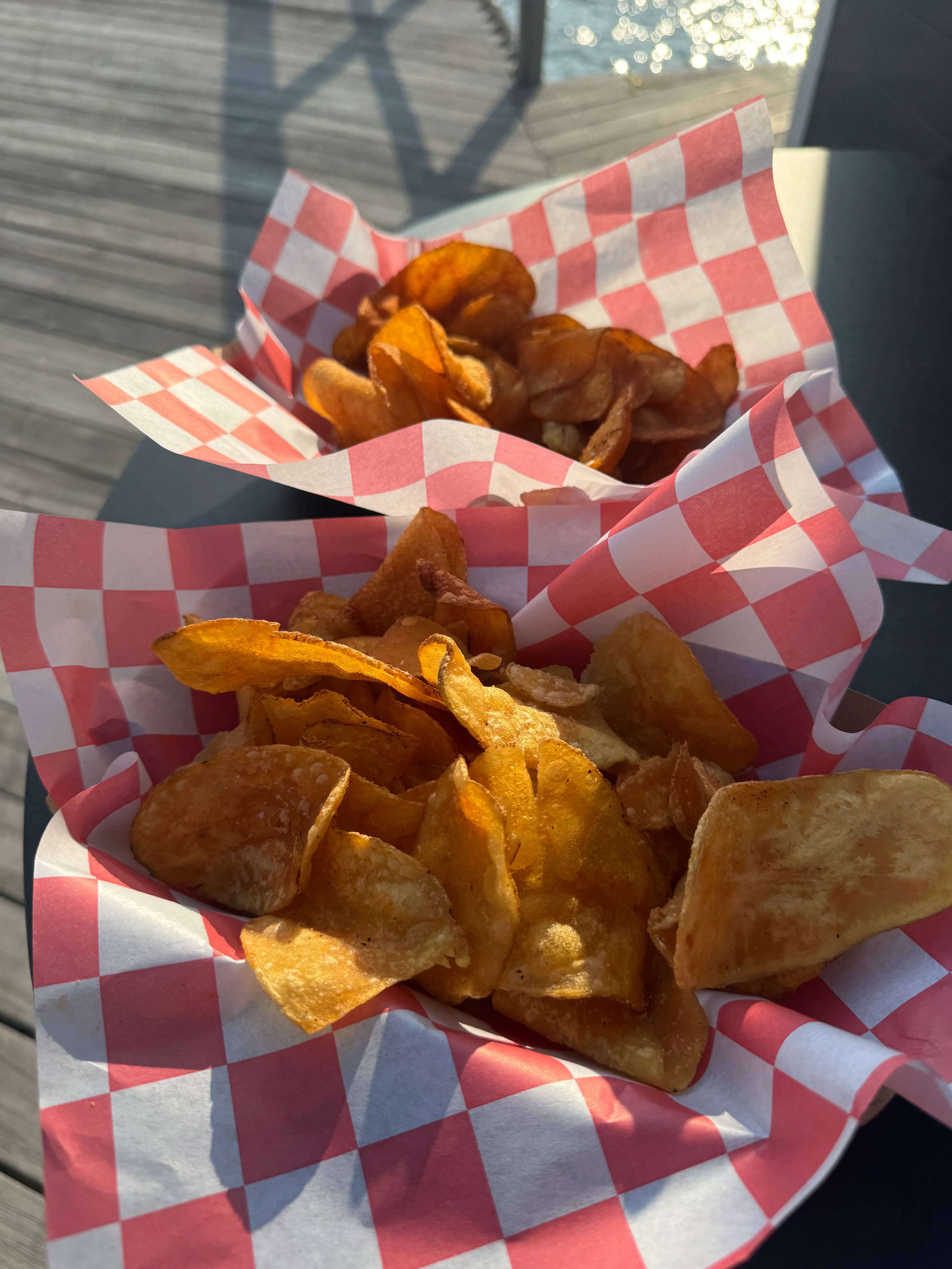 Crispy homemade potato chips in red checkered paper