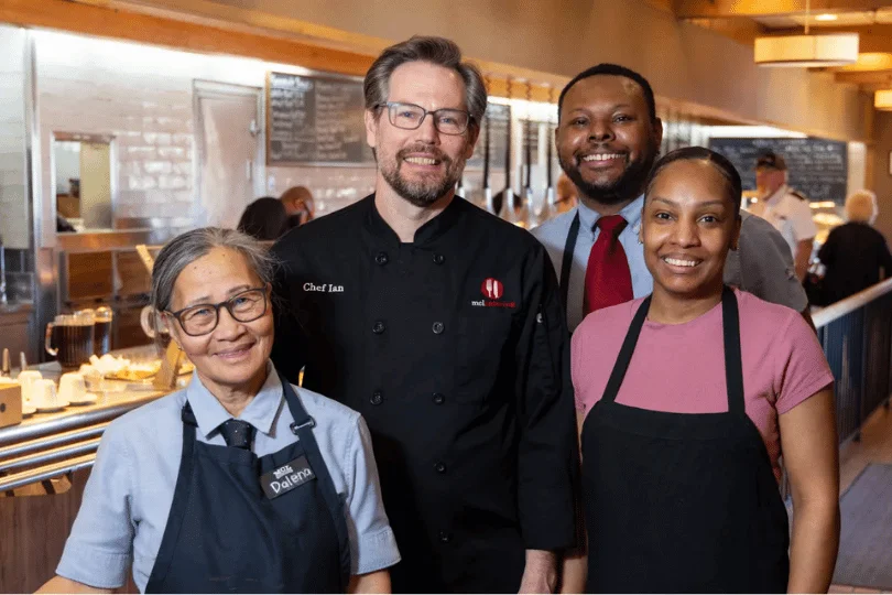 Restaurant staff posing together in a modern dining space