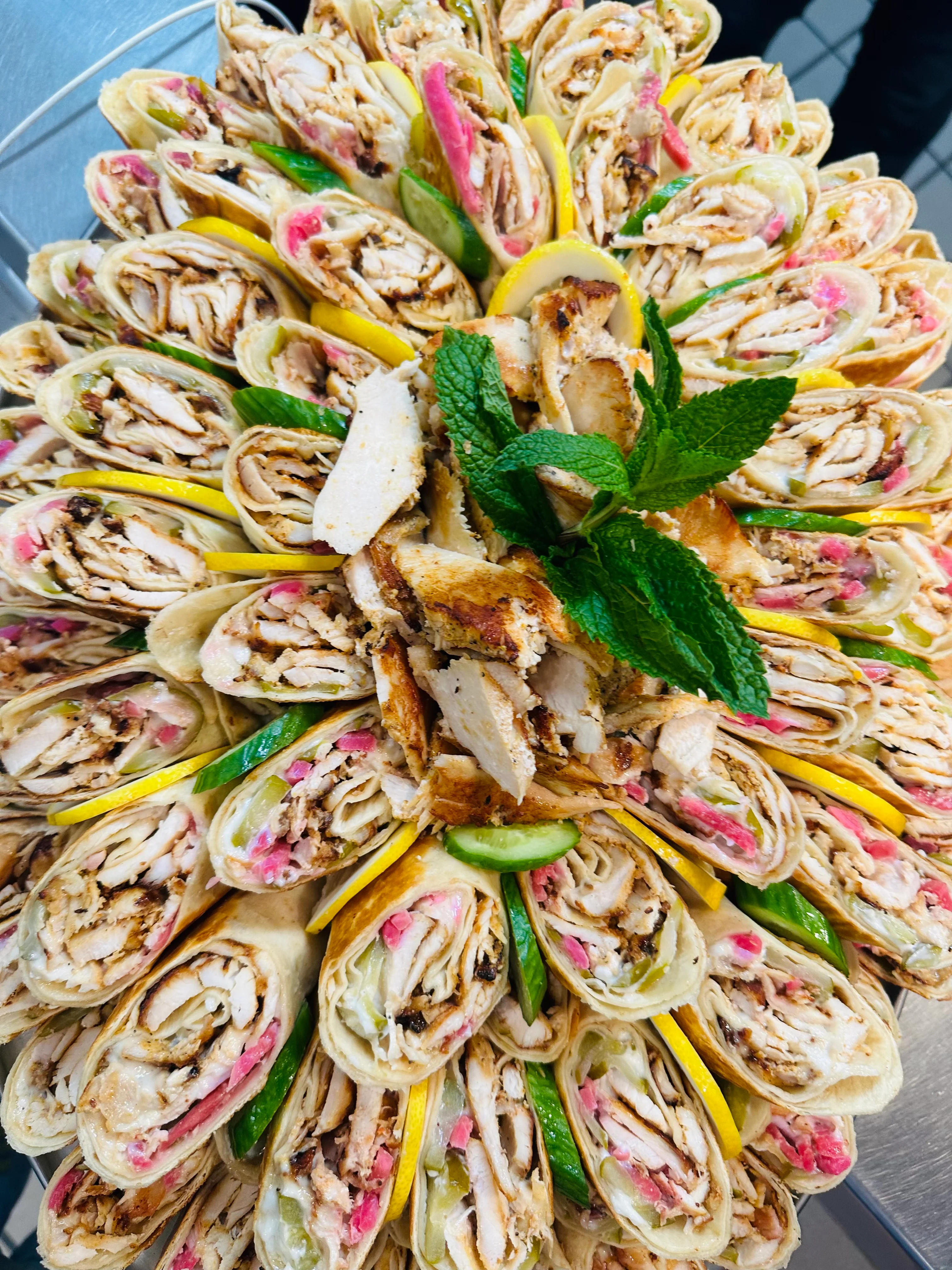 Platter of Middle Eastern shawarma wraps garnished with mint