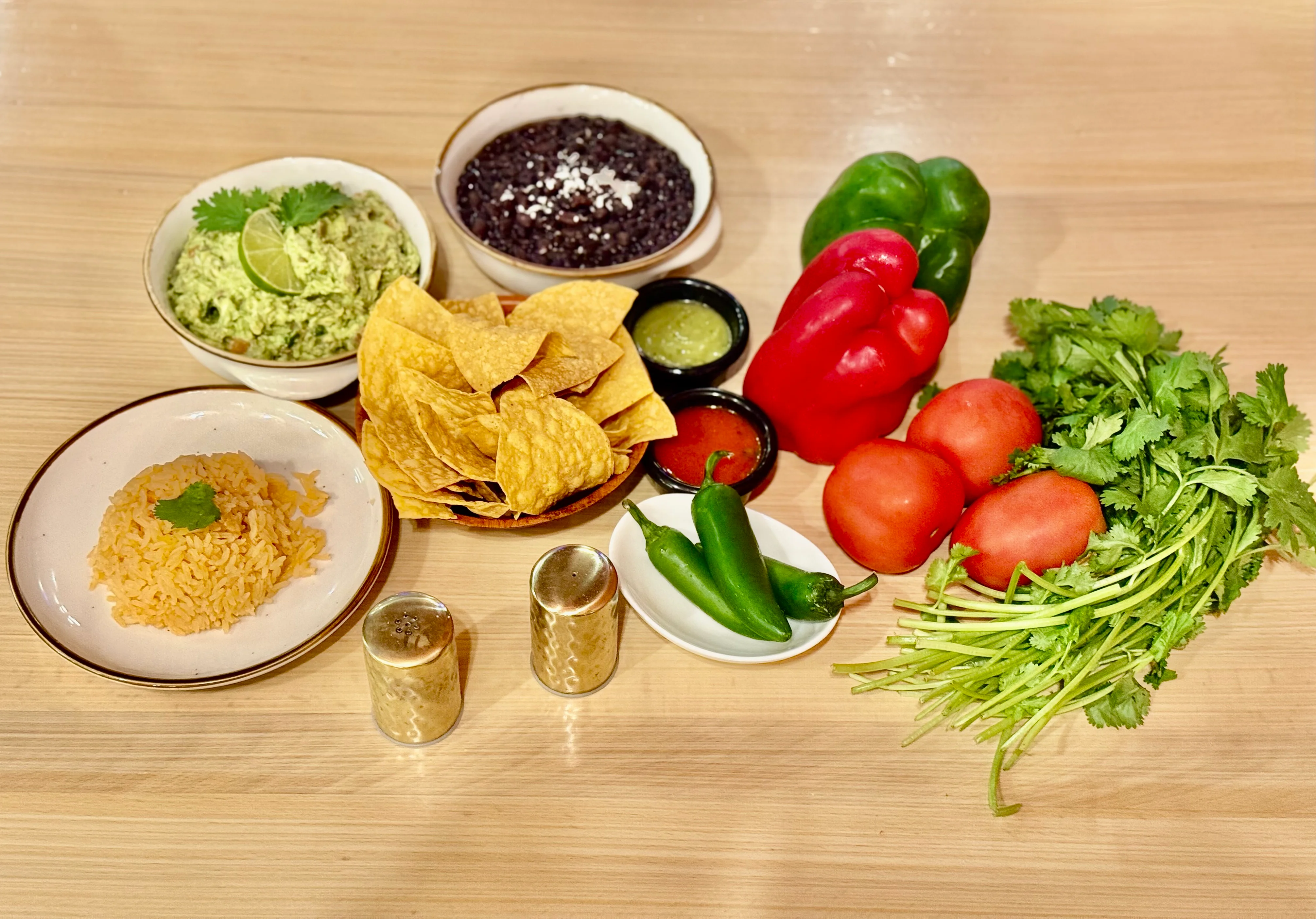 Colorful Mexican guacamole platter with chips and fresh ingredients