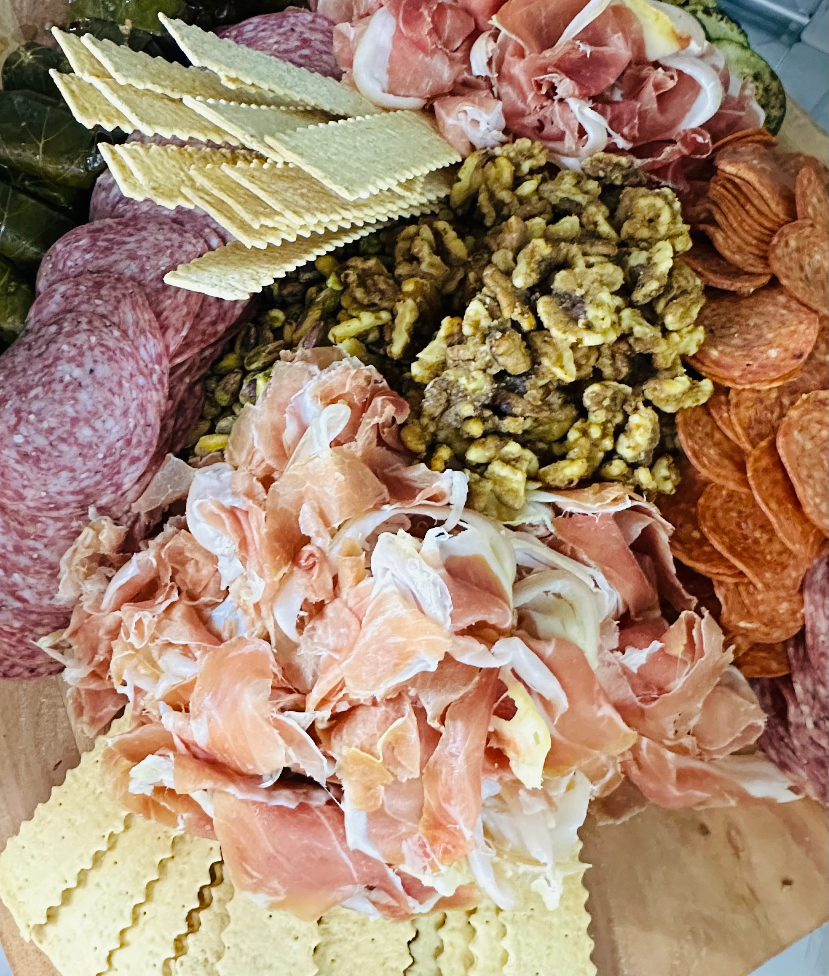 A large charcuterie board filled with an assortment of meats, cheeses, crackers, and nuts, visually appealing and ready for sharing.