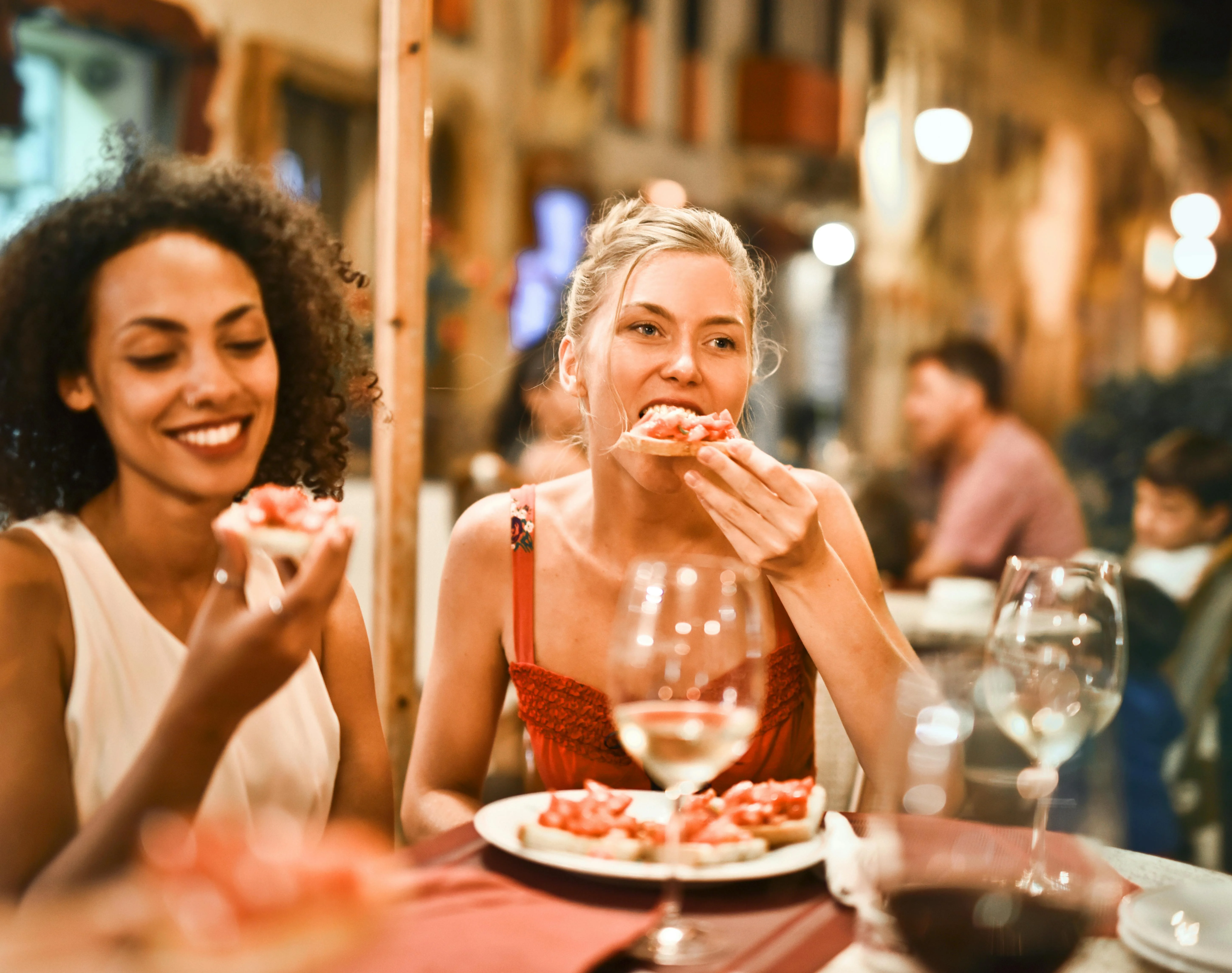 Two friends enjoying bruschetta at a cozy restaurant