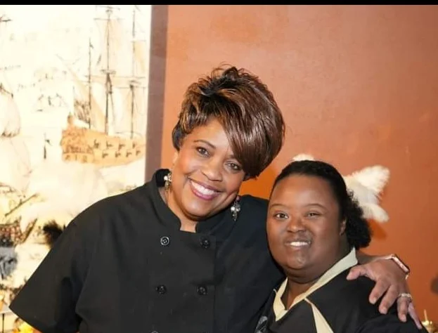 Two chefs smiling in a cozy restaurant setting