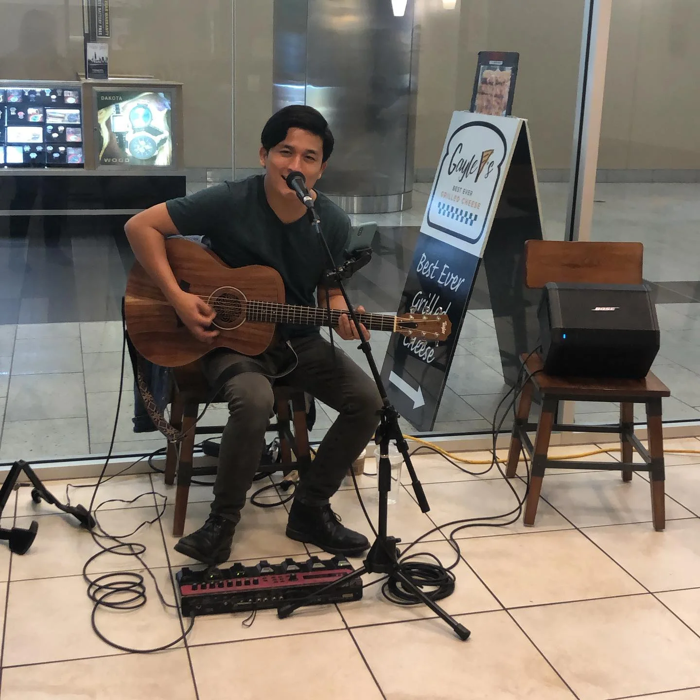 Musician performing live with guitar in a cozy restaurant setting