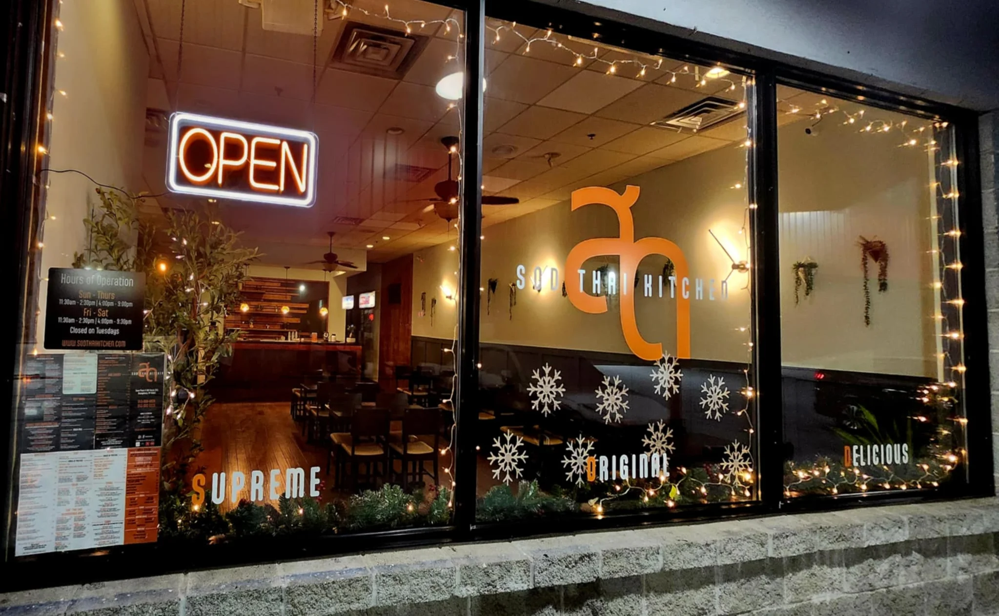 Cozy Thai restaurant exterior with open sign and festive decor