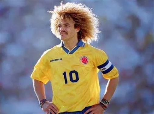 A person wearing a yellow sports jersey with a number on it, standing confidently on a field.