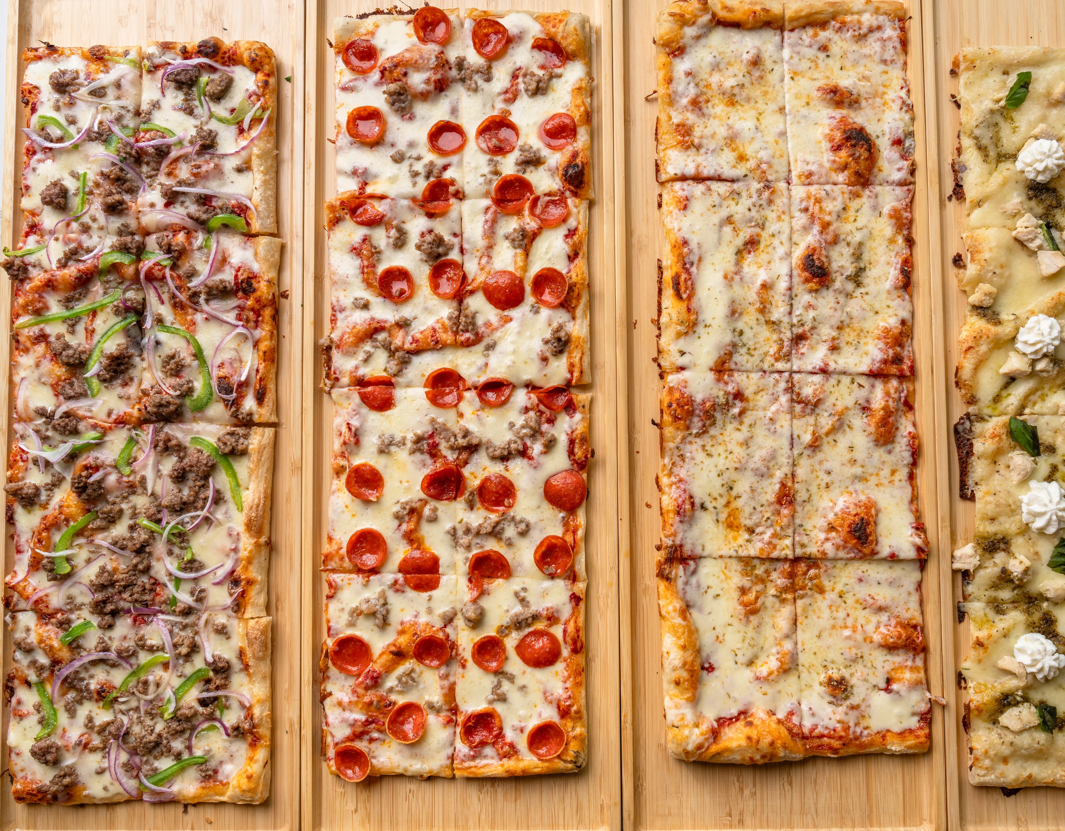 Variety of gourmet pizzas on wooden boards